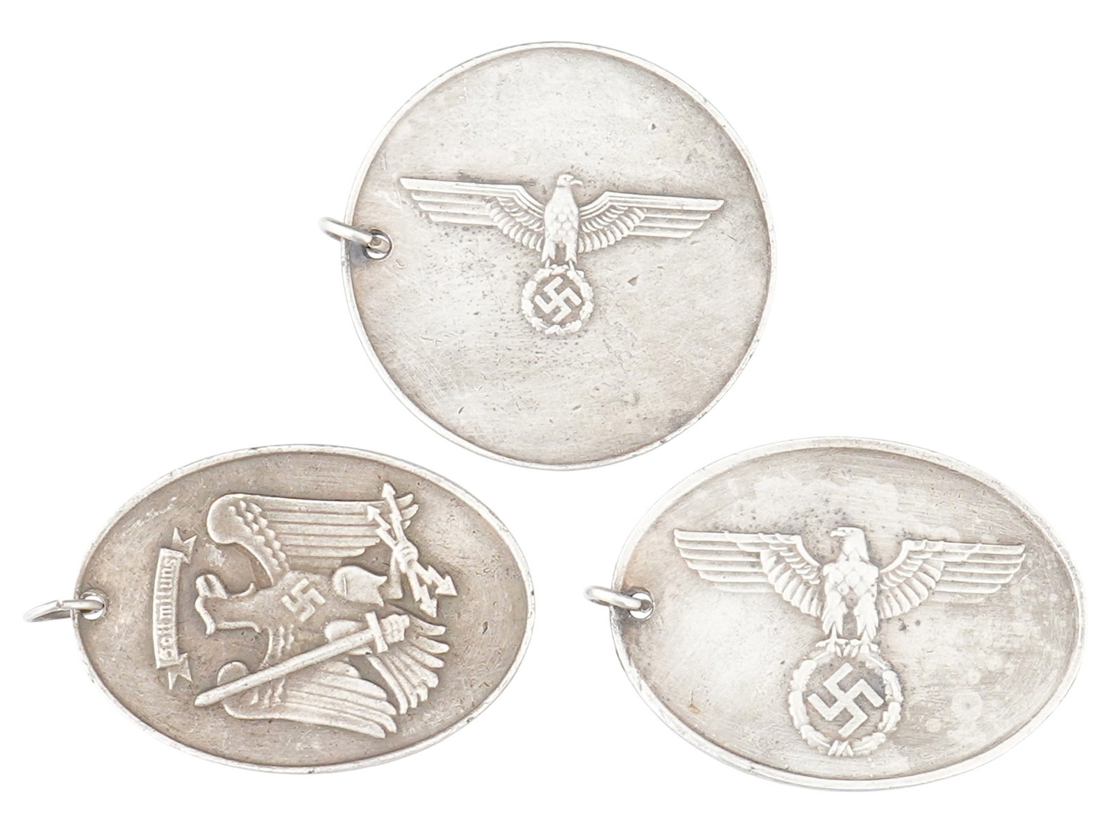 WWII TYPE NAZI GERMAN GESTAPO AND MILITARY ID TAGS: A lot of three World War II model Nazi German aluminum Secret State and Military Police identification tags. Each piece features ID numbers, department name, Reichsadler and swastika symbols. Second W