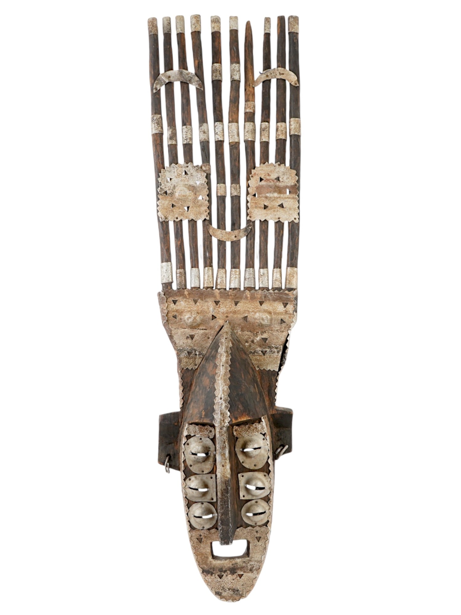 TRADITIONAL AFRICAN TRIBAL ART HAND CARVED WOODEN MASK: A traditional African hand-carved wooden mask featuring three layers of pierced eyes with metal fittings, a large square open mouth, and ears adorned with earrings. The headdress is composed of ten lo