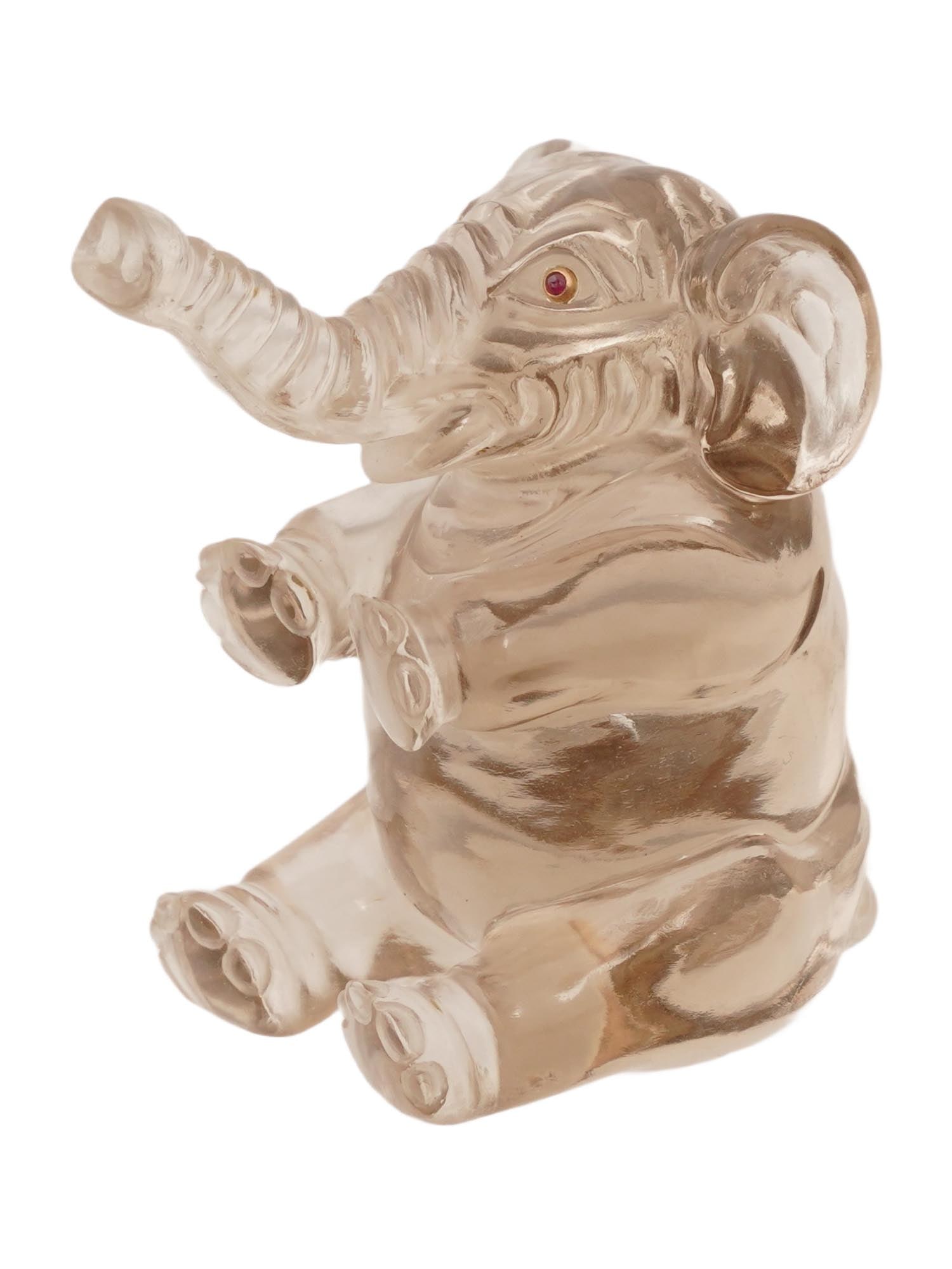 RUSSIAN SMOKY QUARTZ GOLD AND RUBY ELEPHANT FIGURINE: A Russian naturalistically hand carved smoky quartz figurine in the shape of a sitting elephant. The figurine is encrusted with Ruby stone eyes in gold settings. Russian Hand Carved Natural Stones Jew