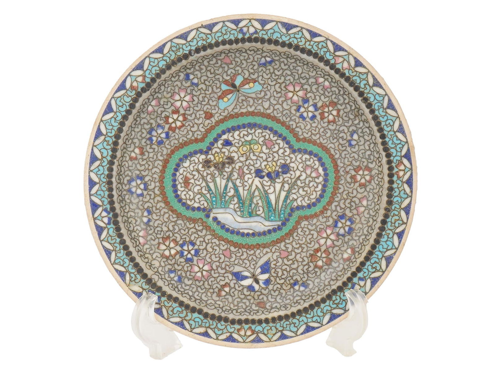 ASIAN POLYCHROME CLOISONNE ENAMEL PORCELAIN PLATE: An Asian polychrome enamel porcelain plate. The plate is adorned with a polychrome enamel medallion representing butterfly and floral motifs surrounded by floral, foliage, circular and butterfly ornam