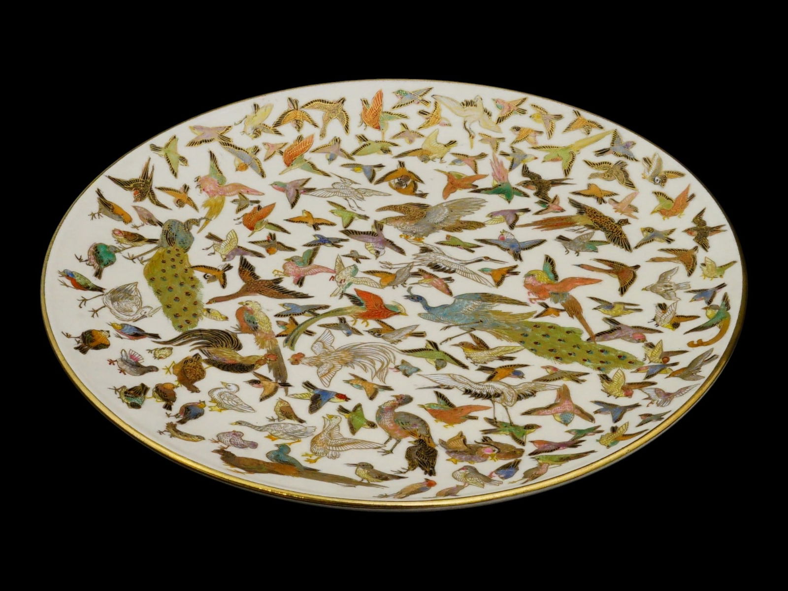ANTIQUE JAPANESE MEIJI SATSUMA PORCELAIN PLATE: An antique Japanese Meiji era Satsuma porcelain plate. Circa late 19th to early 20th century. The circular dish on a high foot depicts a wide variety of birds, including cranes, peacocks, ducks, swall
