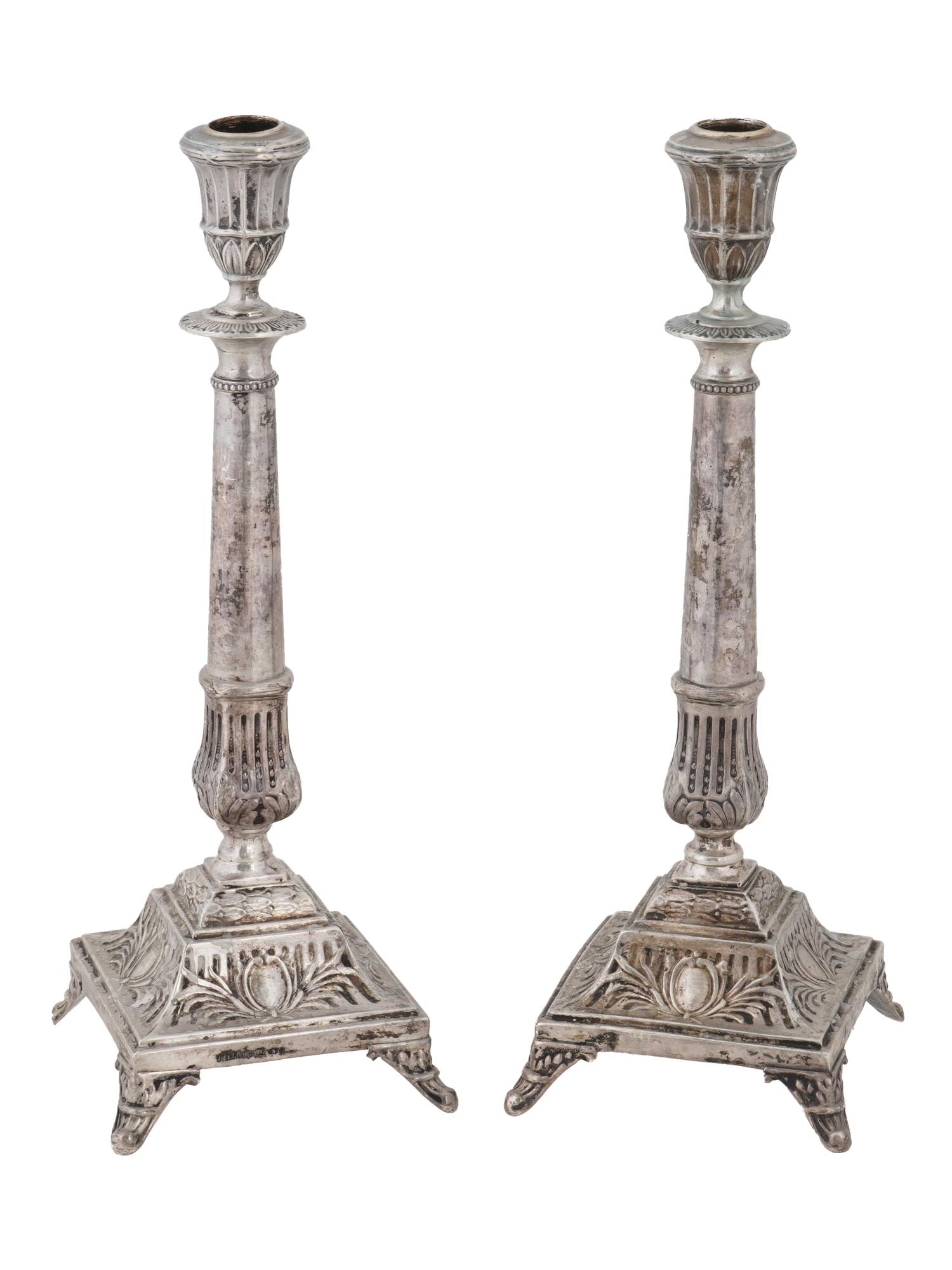 ANTIQUE POLISH WARSAW SILVER CANDLESTICKS BY J EHRLICH: A pair of rare antique Polish Warsaw 800 silver candle holders. Footed pieces of classic column shape with embossed cartouches and leaf motifs. Both items are hallmarked with J. Ehrlich Polish Warsaw