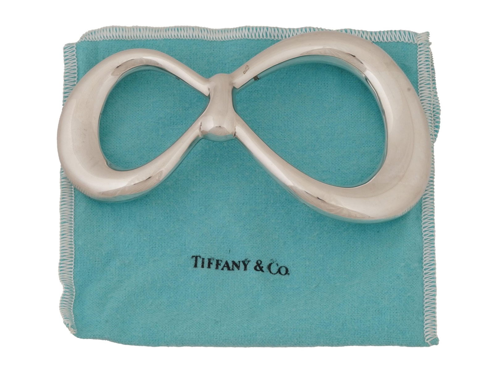 ELSA PERETTI TIFFANY CO 925 SILVER BOW BELT BUCKLE: A vintage elegant Tiffany and Co 925 sterling silver belt buckle in the form of a bow, designed by Elsa Peretti. Marked with Peretti, Tiffany and Co, Italy, Sterling, 925, 1975. Comes with a branded b