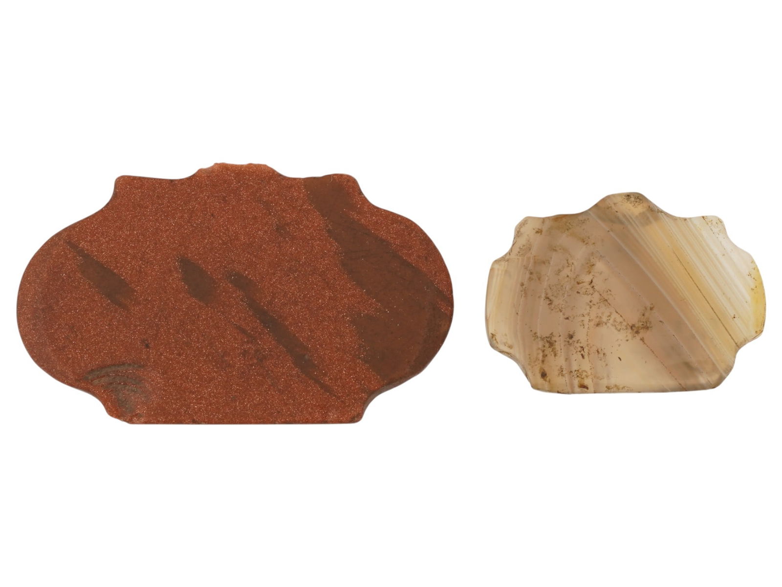 ANCIENT HOLY LAND REGION CARVED AGATE JASPER PENDANTS: A pair of ancient carved stone pendants, dating to the 2nd millennium BC, from the Holy Land region. Executed in agate and jasper, the pendants feature a distinctive scalloped form, reflecting early l