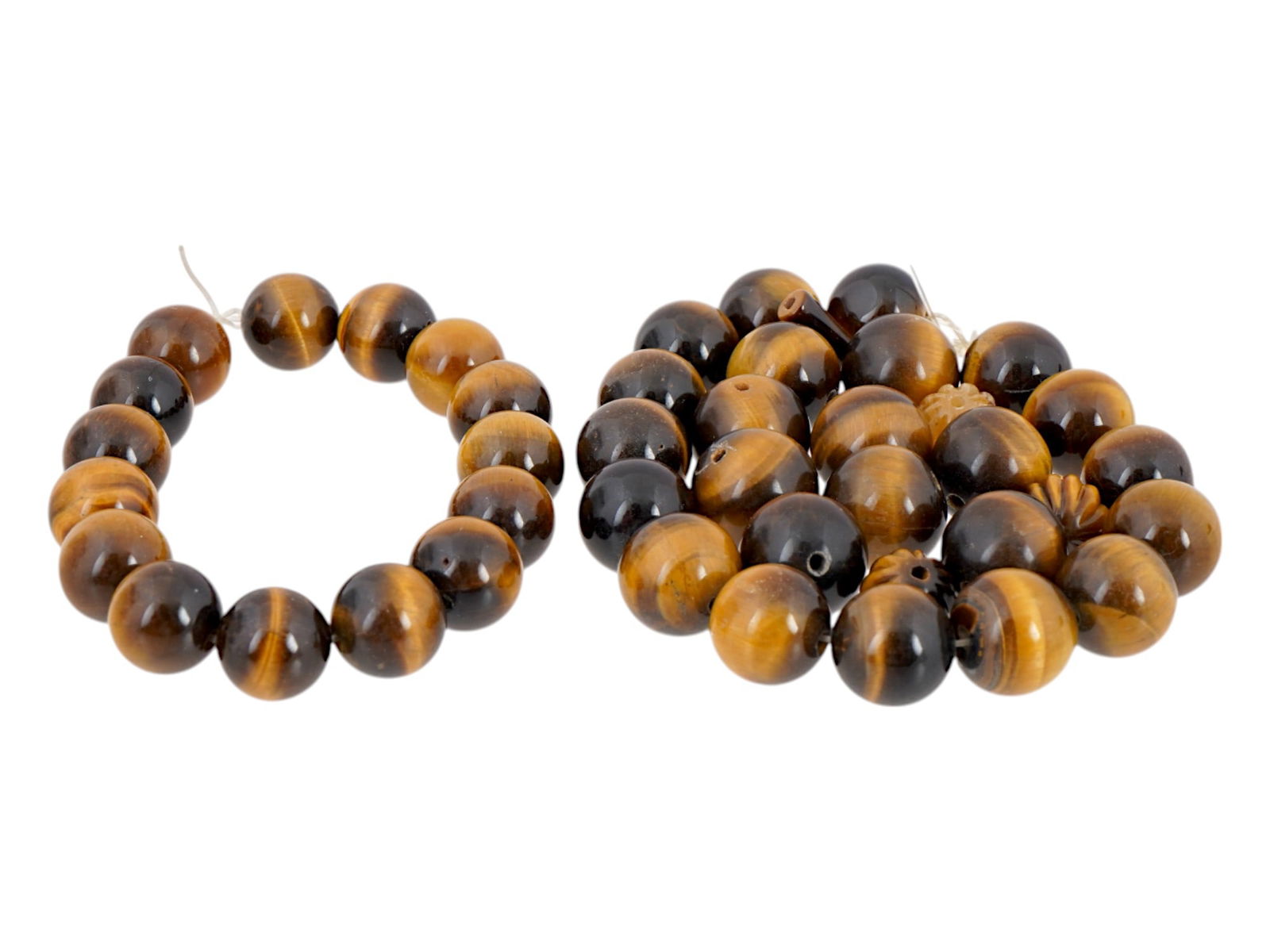 SET OF CARVED TIGERS EYE BEADS FOR JEWELRY DESIGNS: A set of carved tigers eye beads. Each bead features a spherical shape and is pierced for stringing. The beads are pre-strung on a temporary fishing line, ready for use in crafting a custom necklace o