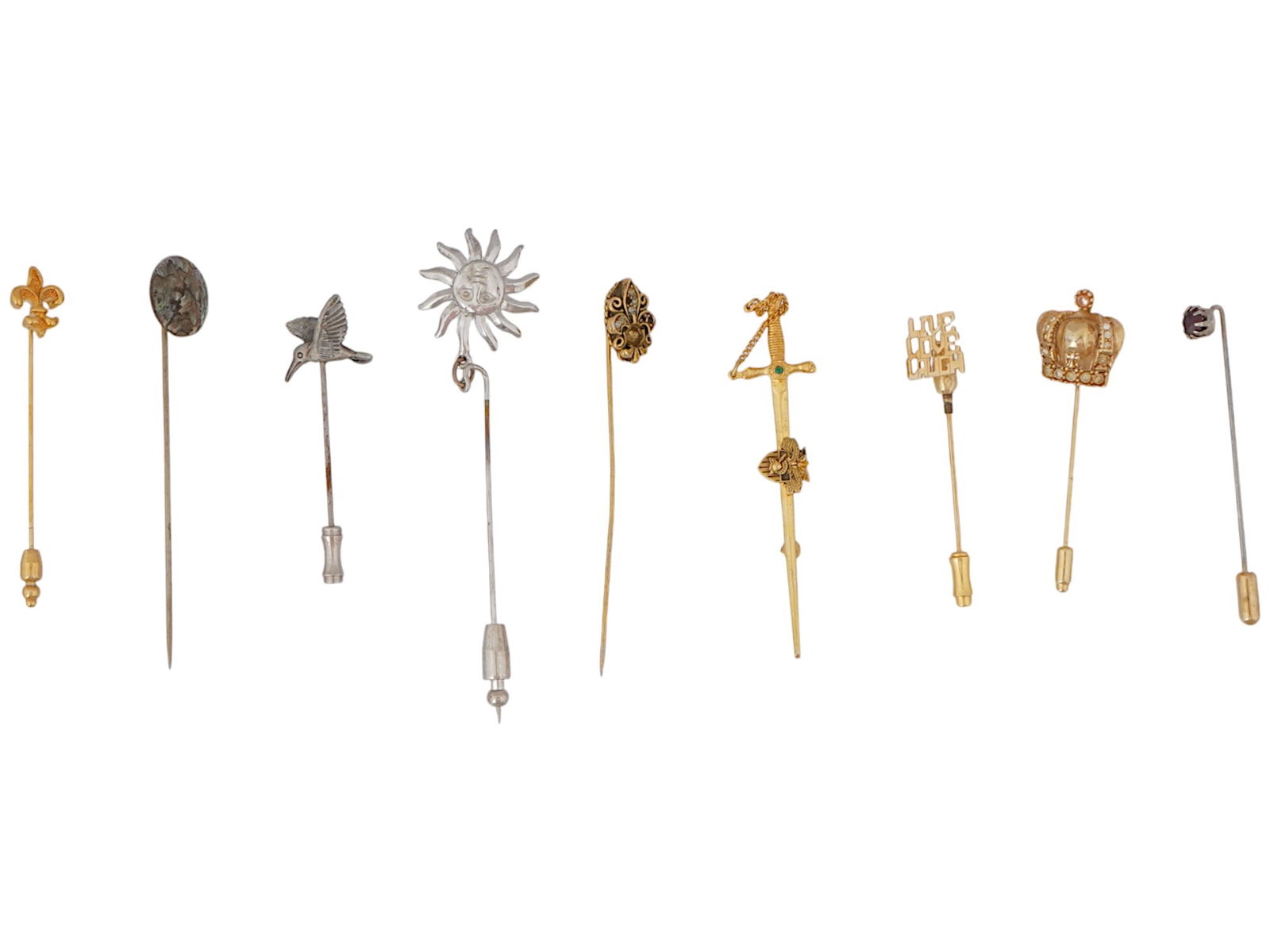 GROUP OF NINE STICK PINS OF VARIOUS DESIGNS: A group of nine stick pins. Each pin features a unique decorative element at the top and a pin backing. Several silver colored pins. One in the shape of the sun, a second in the shape of a hummingbird