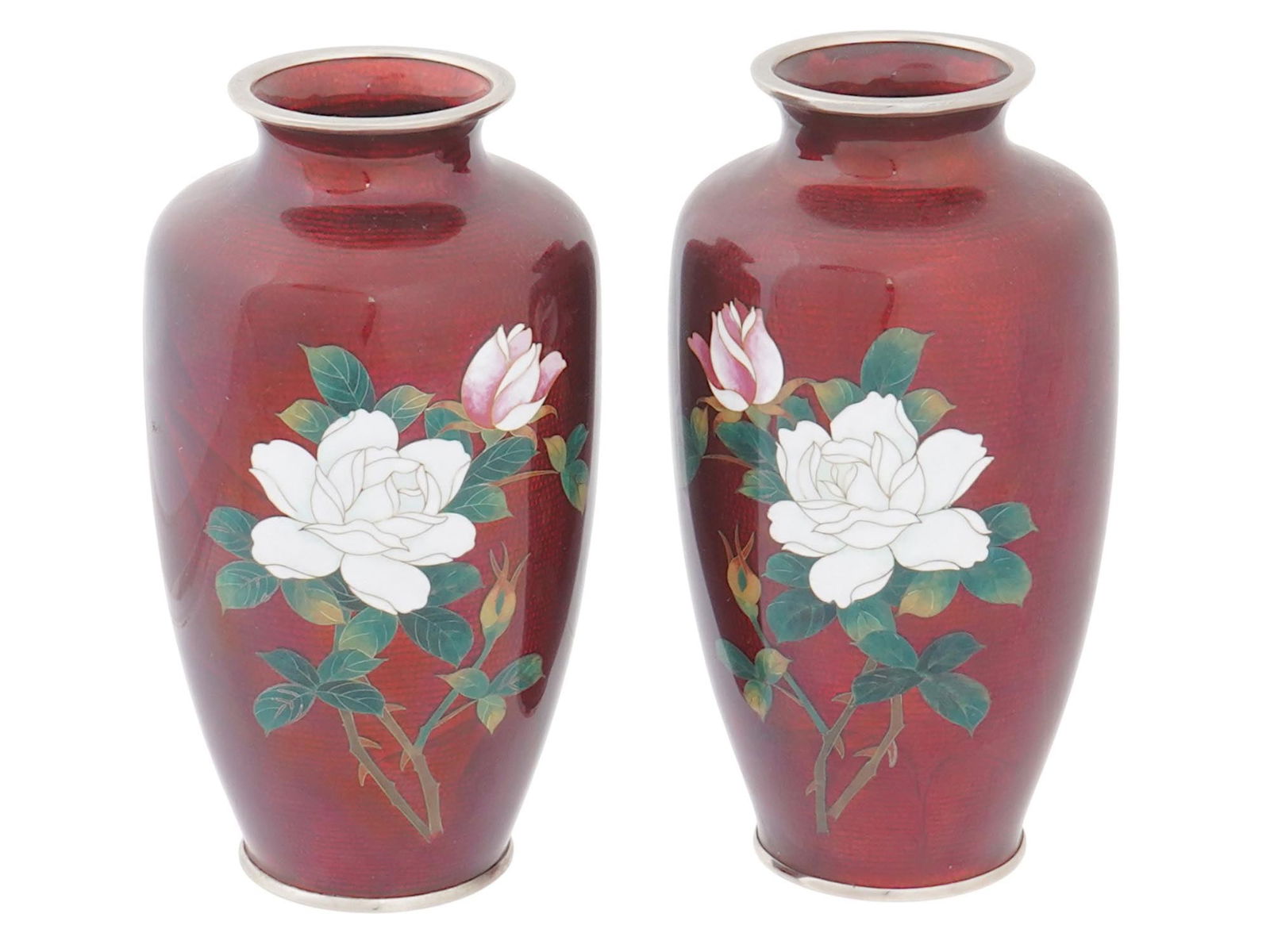 PAIR OF VTG JAPANESE GUILLOCHE CLOISONNE ENAMEL VASES: A pair of vintage Japanese enamel vases. The ground of each vase is covered with a red guilloche enamel and adorned with a floral rose pattern made in the cloisonne technique. Inscribed Japan Sato Clo