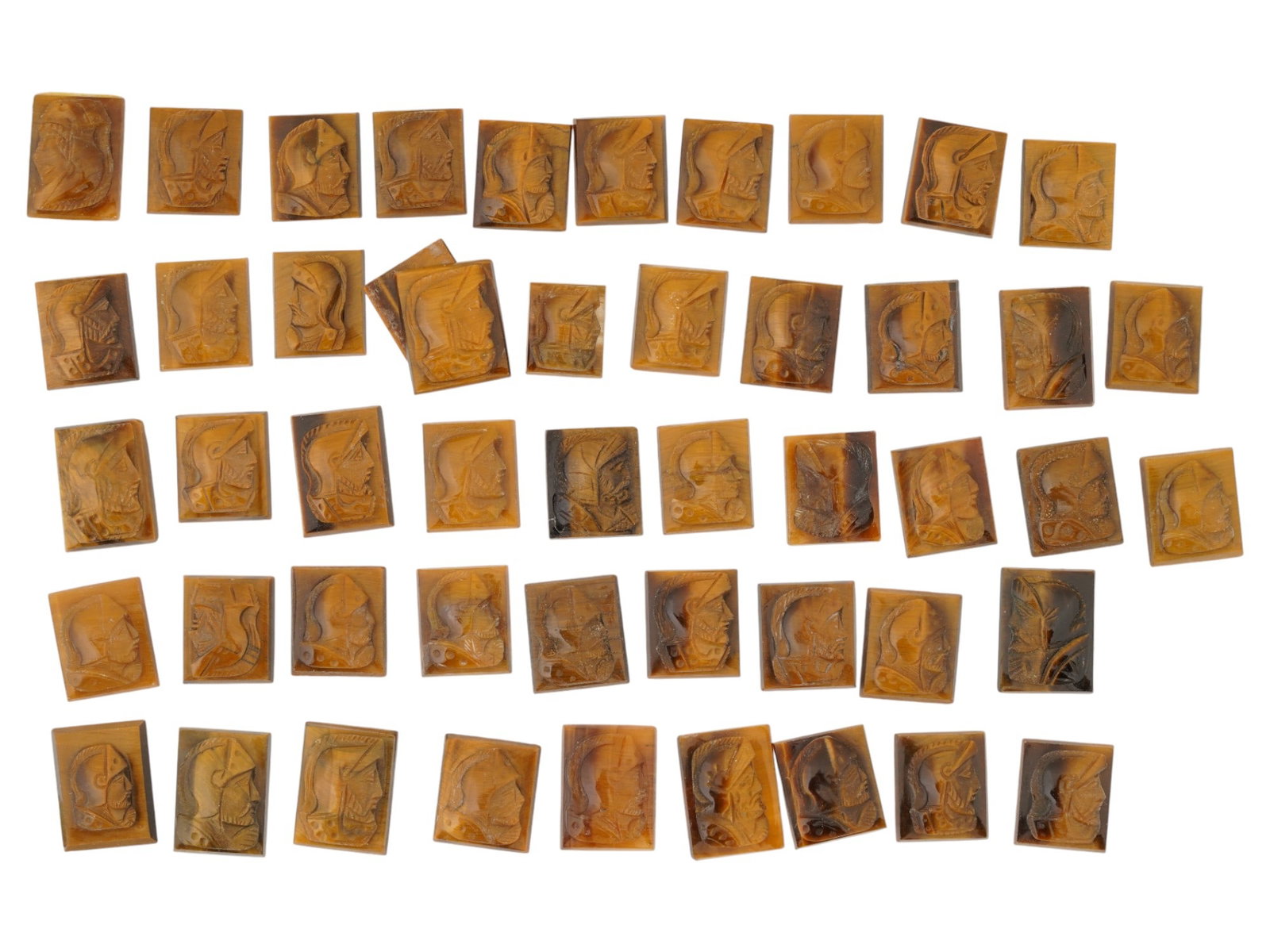 COLLECTION OF PORTRAIT CARVED TIGERS EYE CAMEOS: A collection of hand carved tigers eye cameos. A total of 50 items. Each piece features a knight profile portrait rendered in high relief. Square shape. Collectible Jewelry And Glyptic Art, Sculpture.