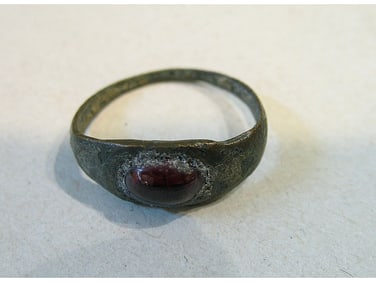 BRONZE RING WITH RED STONE.