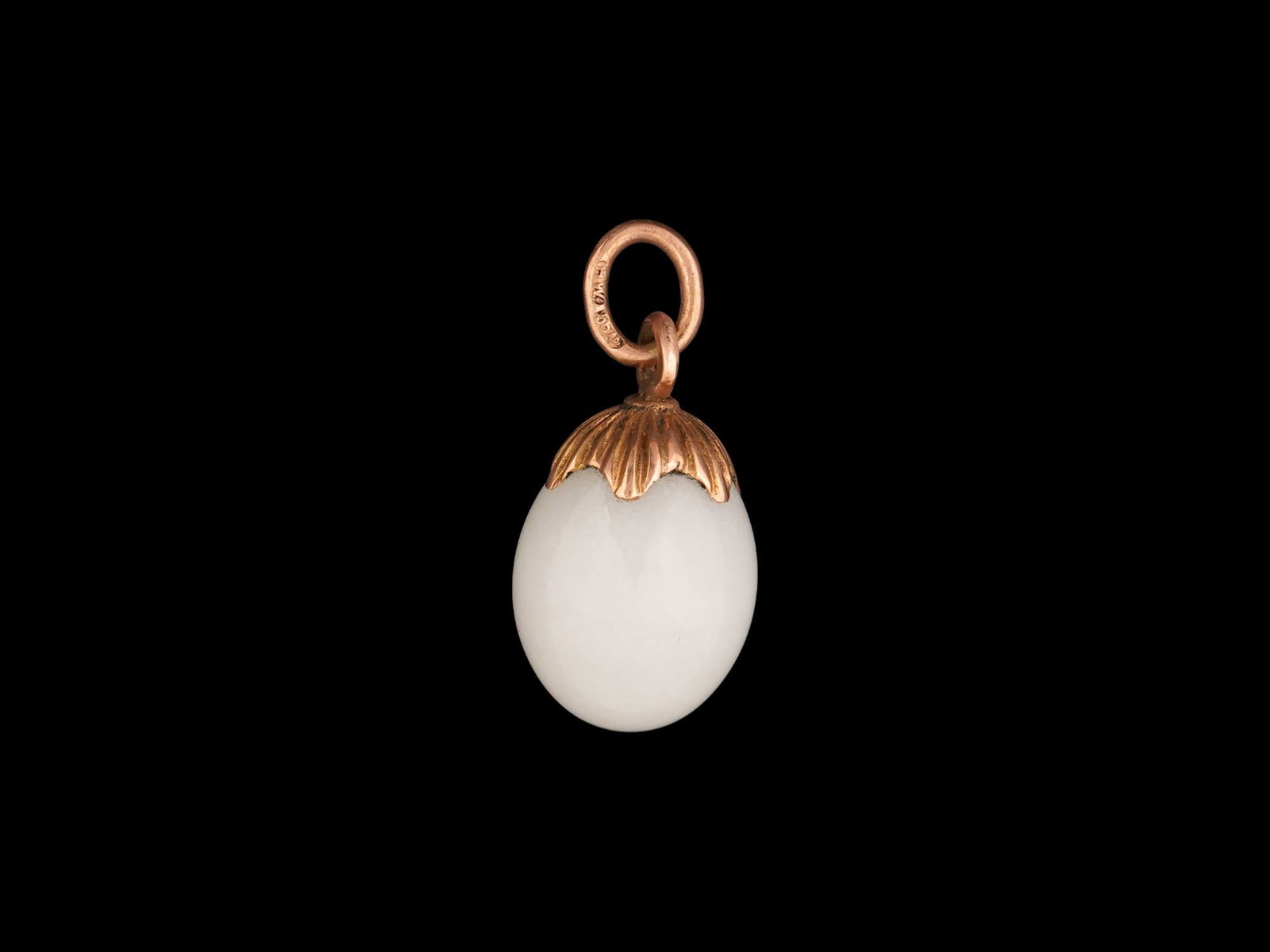 RUSSIAN GOLD AND CARVED WHITE JADE EASTER EGG PENDANT: A Russian gold and carved white jade Easter egg pendant crafted in the shape of an acorn. Hallmarked with the 56 Russian gold proof for 14K and makers marks, on the suspension ring. Collectible Russia