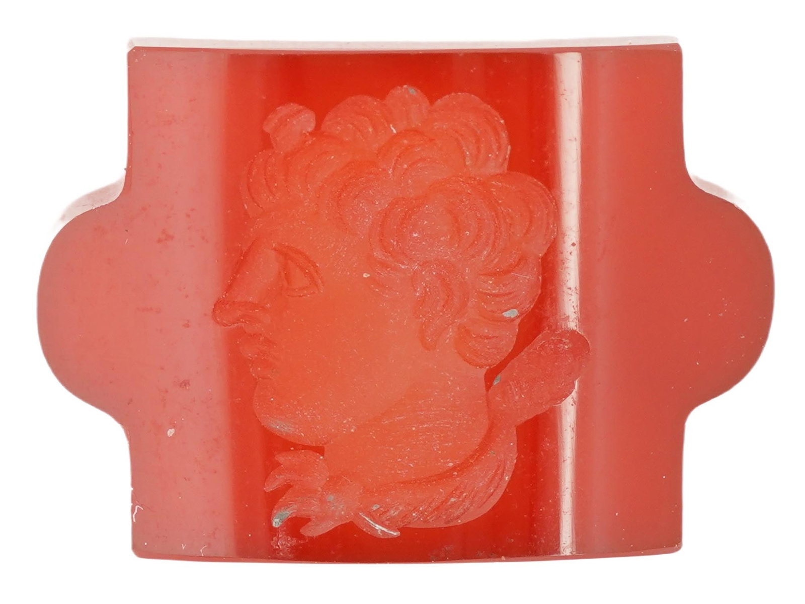 ANTIQUE CARNELIAN MALE PORTRAIT CAMEO: An antique carnelian cameo of rectangular shape, exquisitely carved with a profile portrait of a young man facing left. The cameo has a raised, slightly curved shape with two ears on the sides and a s