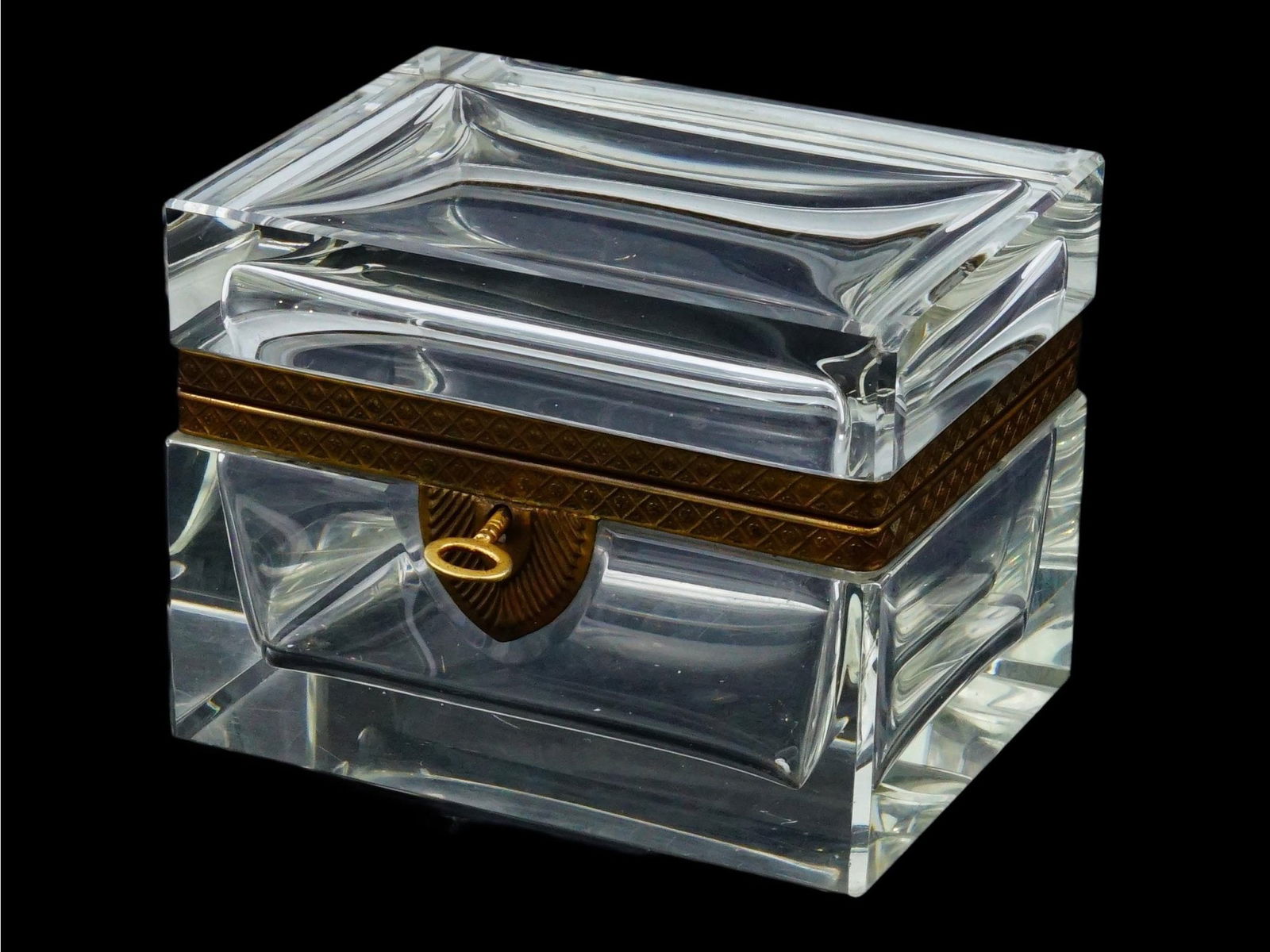 ANTIQUE FRENCH GILT BRONZE MOUNTED CRYSTAL TRINKET BOX: An antique French gilt bronze mounted crystal trinket box, dating to the 19th to early 20th century, a form traditionally used as a jewelry or dressing table box. The piece features cut clear crystal