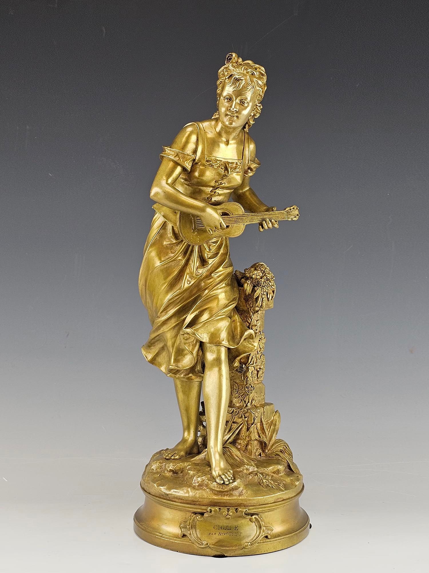 EUTROPE BOURET FRENCH 19 C BRONZE FEMALE FIGURINE: Eutrope Bouret, French, 1833 to 1906, gilded cast bronze sculpture. Figure of a young woman holding a guitar in her hands. Title plaque Cigale on the base. Signed on the column. Dated late 19th centur