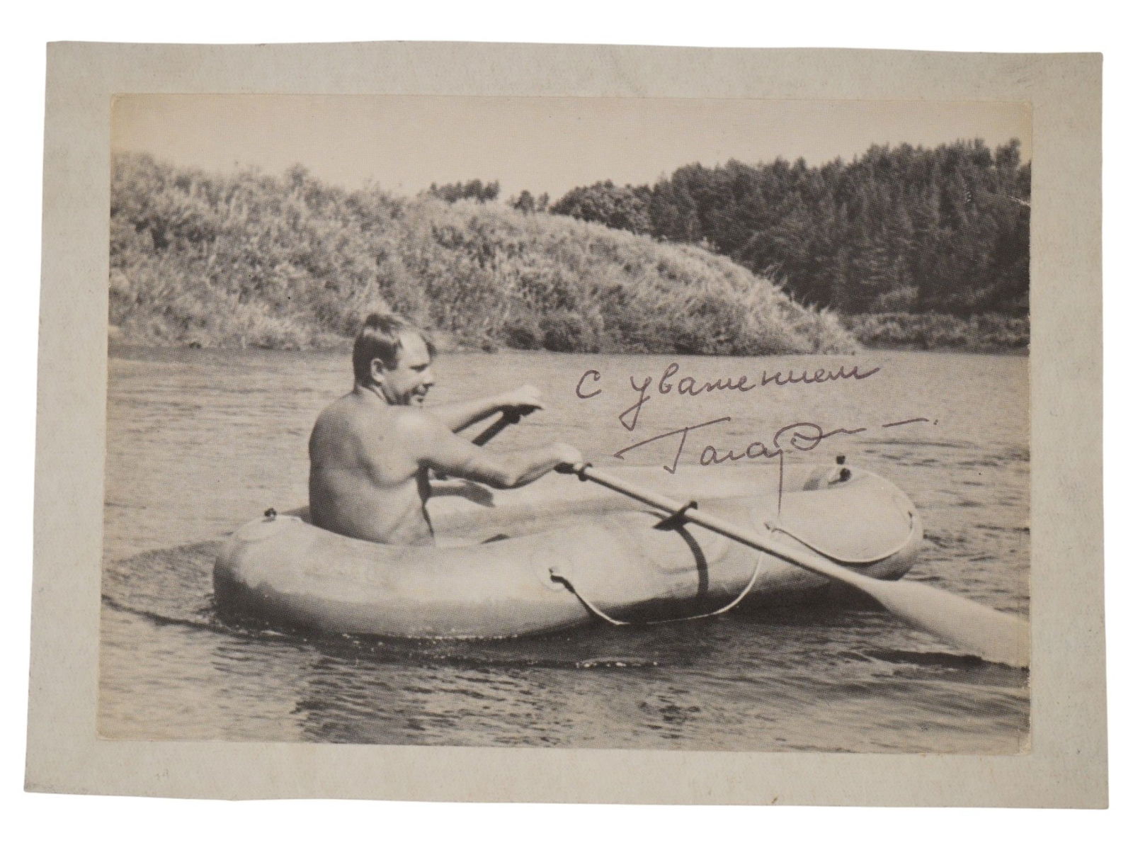 VINTAGE PHOTO SOVIET COSMONAUT YURI GAGARIN AUTOGRAPHED: A vintage photograph of Soviet cosmonaut Yuri Gagarin, the first human to journey into outer space, shown relaxing on the Ugra River circa 1970. Bears a handwritten inscription reading With Respect,