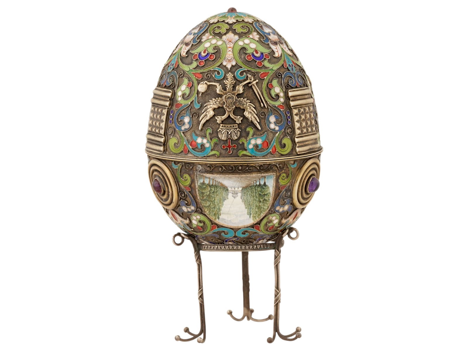 RUSSIAN SILVER GEMSTONES ENAMEL EASTER EGG WITH STAND: A large Russian 88 Silver and enamel Easter egg. The ware is separated into two halves. A gold wash interior. The exterior of the egg is enameled with polychrome scrollwork and floral patterns made