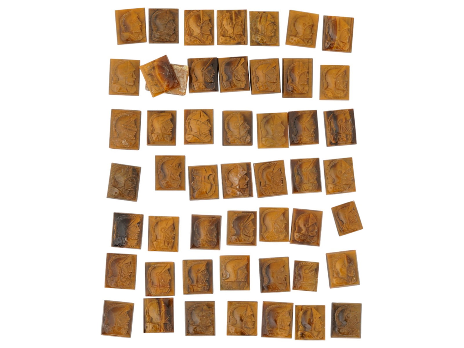 COLLECTION OF PORTRAIT CARVED TIGERS EYE CAMEOS: A collection of hand carved tigers eye cameos. A total of 50 items. Each piece features a knight profile portrait rendered in high relief. Square shape. Collectible Jewelry And Glyptic Art, Sculpture.