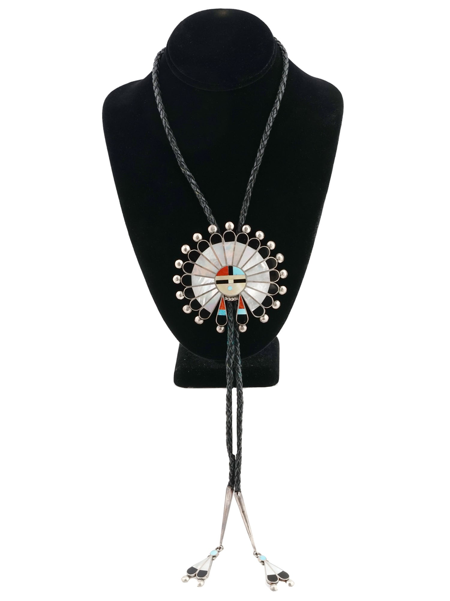 ZUNI TRIBE STERLING SILVER INLAY PEACOCK BOLO TIE: A mid-20th century Native American Zuni bolo tie. Braided leather cord with sterling silver peacock-shaped slide and aiguillettes. The silver parts are garnished with gemstone channel inlay, mother-of