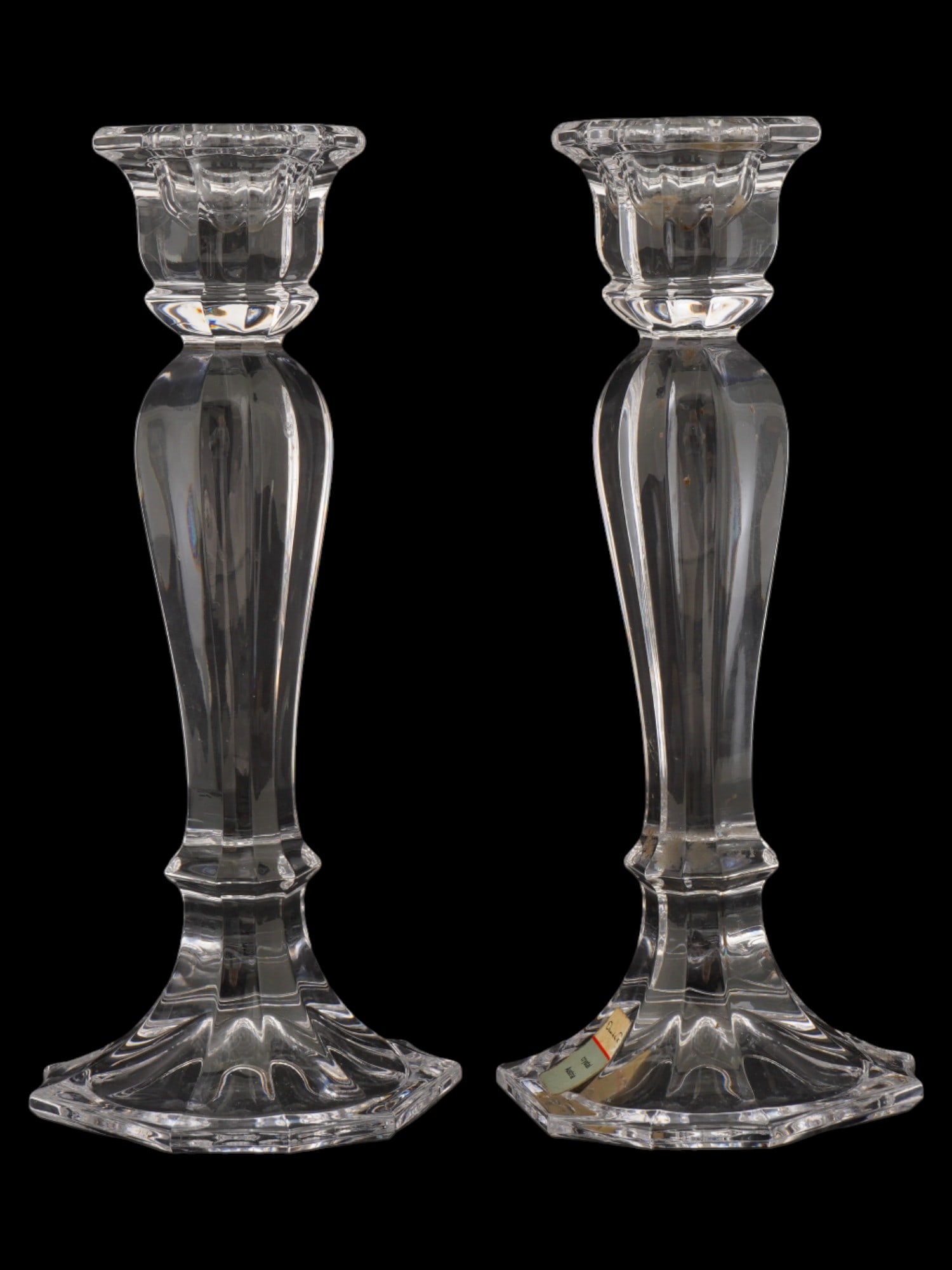 AUSTRIAN OSCAR DE LA RENTA CRYSTAL CANDLESTICK HOLDERS: A pair of vintage Austrian Oscar de la Renta lead crystal candlestick holders. Both candlesticks feature a lobed design, reminiscent of a column with a flower-shaped top. Marked with Oscar de la Renta