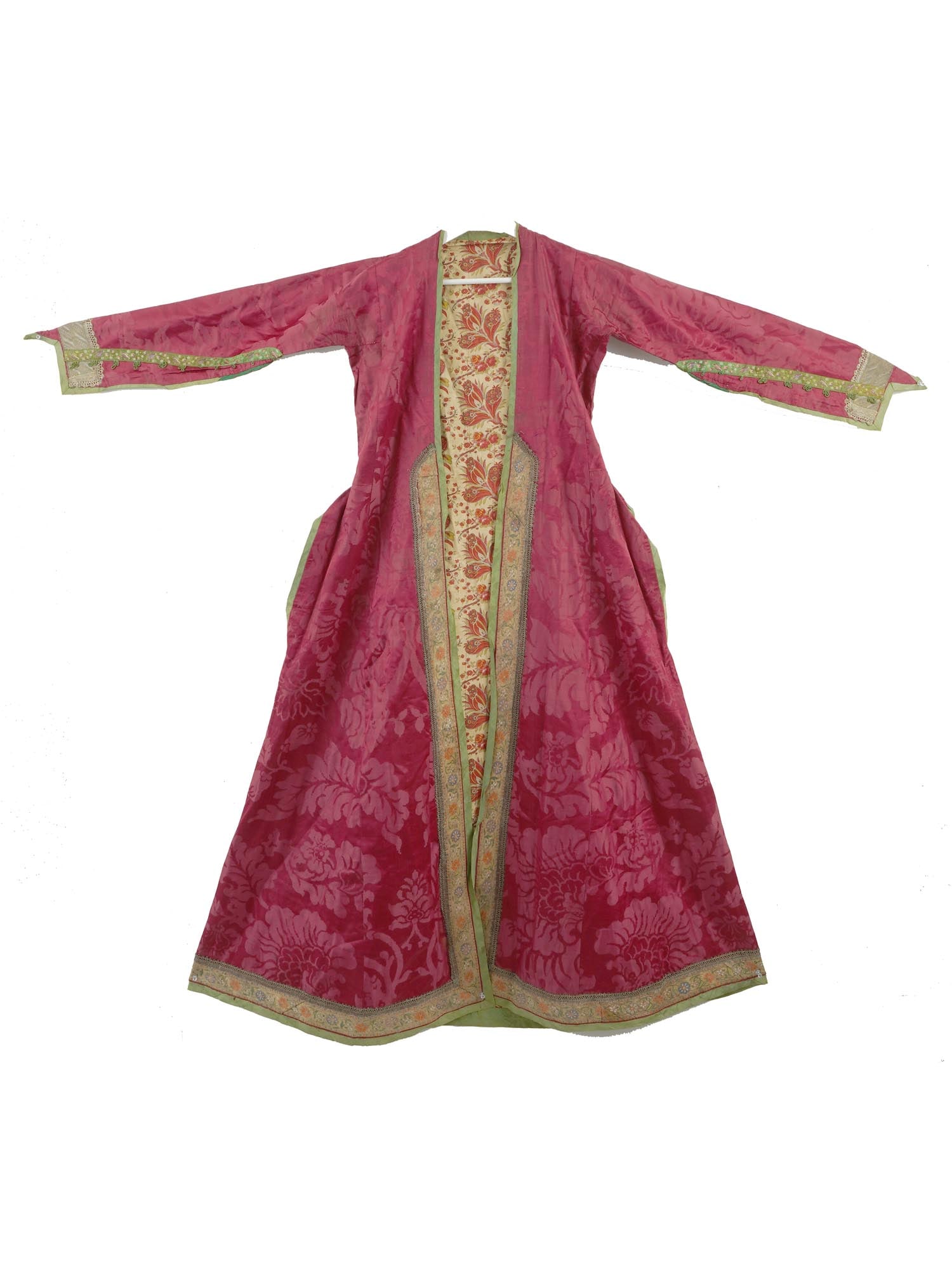 ANTIQUE PERSIAN SAFAVID SILVER EMBROIDERED SILK ROBE: An antique Persian Iranian Safavid silk robe. The robe features a bold crimson base adorned with intricate floral patterns, complemented by ornate silver and golden embellishments. The robe exhibits d