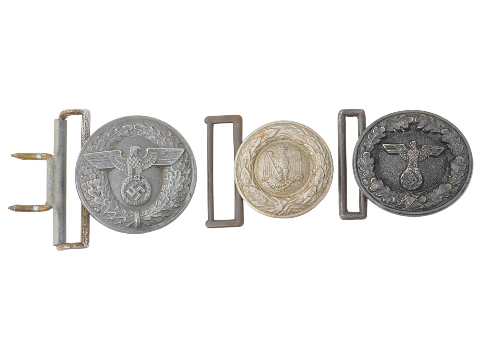 A GROUP OF THREE WWII NAZI GERMAN BELT BUCKLES: A group of three WWII Nazi German belt buckles, including a State Forestry buckle, a Justice Officials buckle, and a Political Leaders buckle. Feature eagles with swastika in various designs. Second W