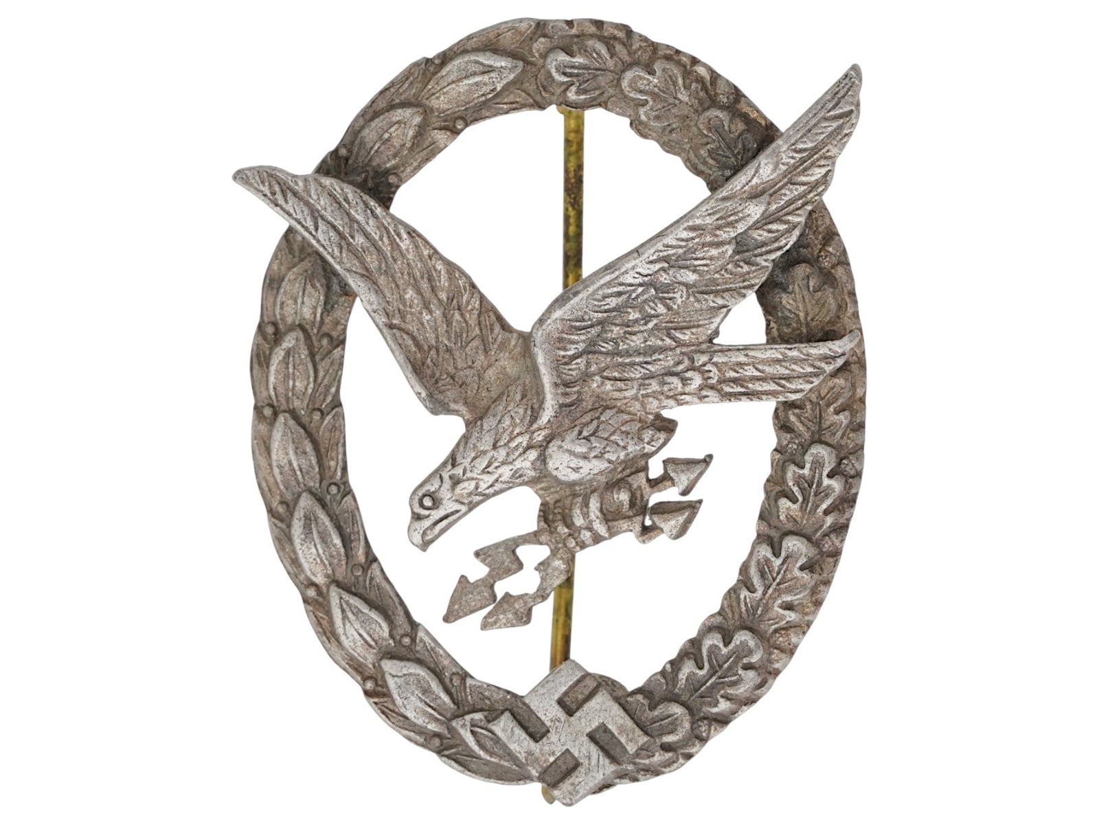 WWII GERMAN LUFTWAFFE RADIO OPERATOR AIR GUNNER BADGE: A WWII German early tombak Luftwaffe radio Operator and Air Gunner Badge. It has a diving eagle at the center surrounded by a laurel and oak leaves wreath. The wreath has the Nazi swastika embossed at