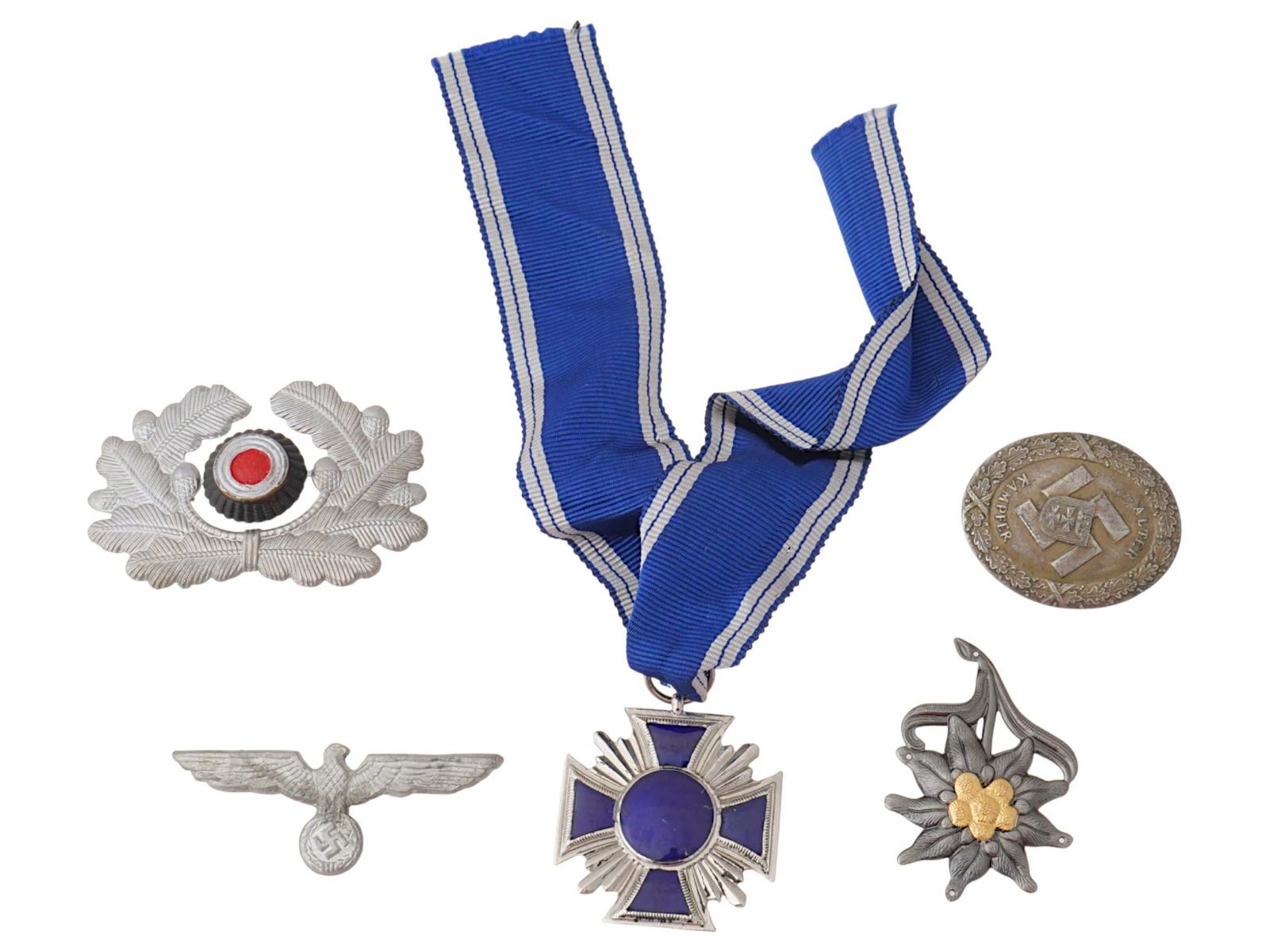 WWII NAZI GERMAN MILITARY INSIGNIA AND MEDALS: A lot of five WWII Nazi German insignia. NSDAP Long Service medal with ribbon. Reichsadler pin. Wehrmacht visor cap cockade. Edelweiss Mountain Infantry field cap badge. Alter Kampfer badge. Collectib