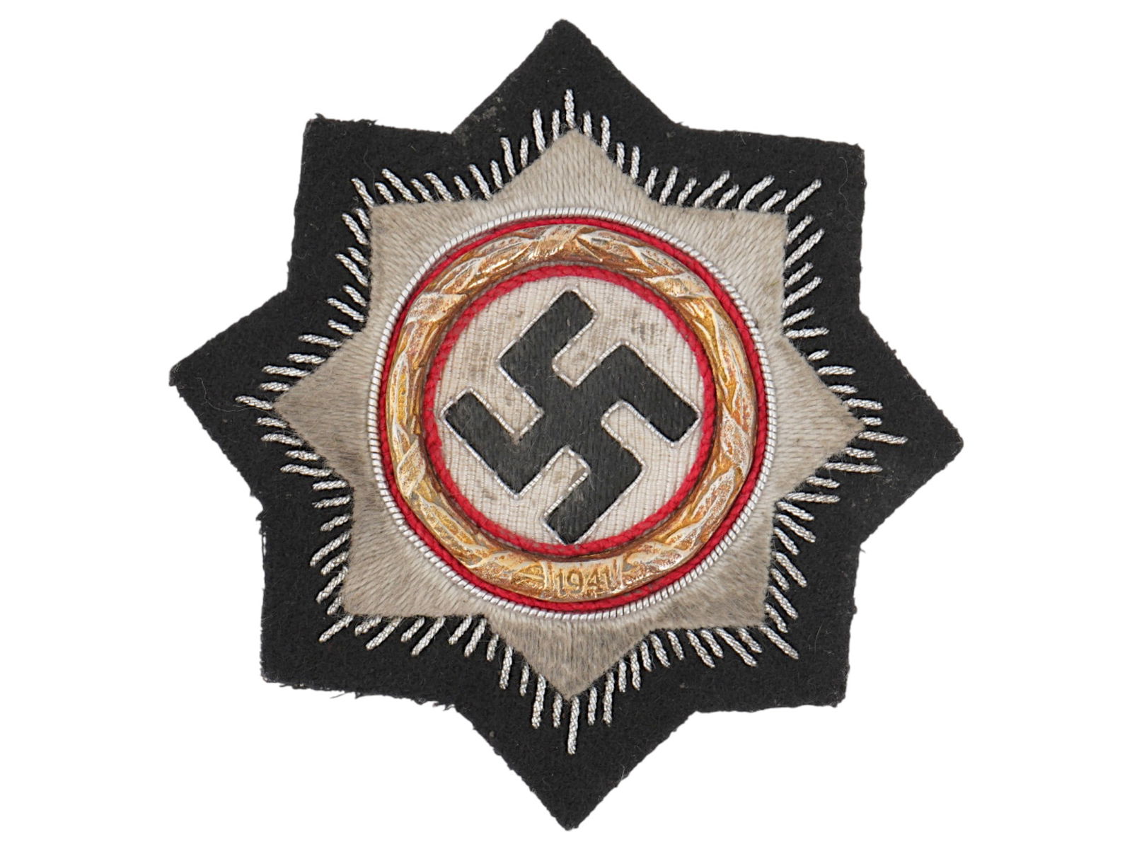 WWII NAZI EMBROIDERED ORDER OF THE GERMAN CROSS IN GOLD: A WWII era Nazi embroidered War Order of the German Cross in Gold. Relief silver bordered black swastika on a white field. All within a gilt metal oak leaf wreath with the date 1941. A dark octagon st