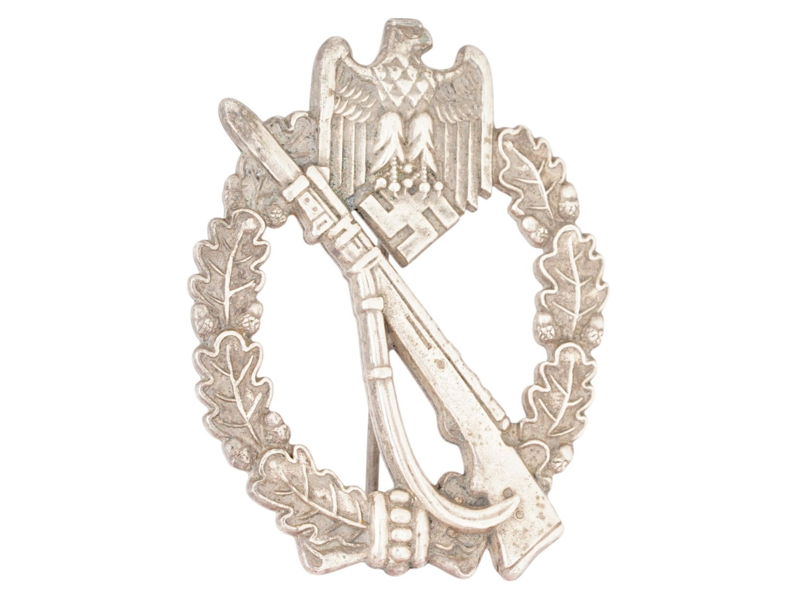 WWII GERMAN WEHRMACHT INFANTRY ASSAULT BADGE: A WWII Nazi German Third Reich Wehrmacht Infantry Assault Badge. The badge is adorned with a relief image of a weapon in the center, a wreath with oak leaves, and a Nazi eagle clutching a swastika ins