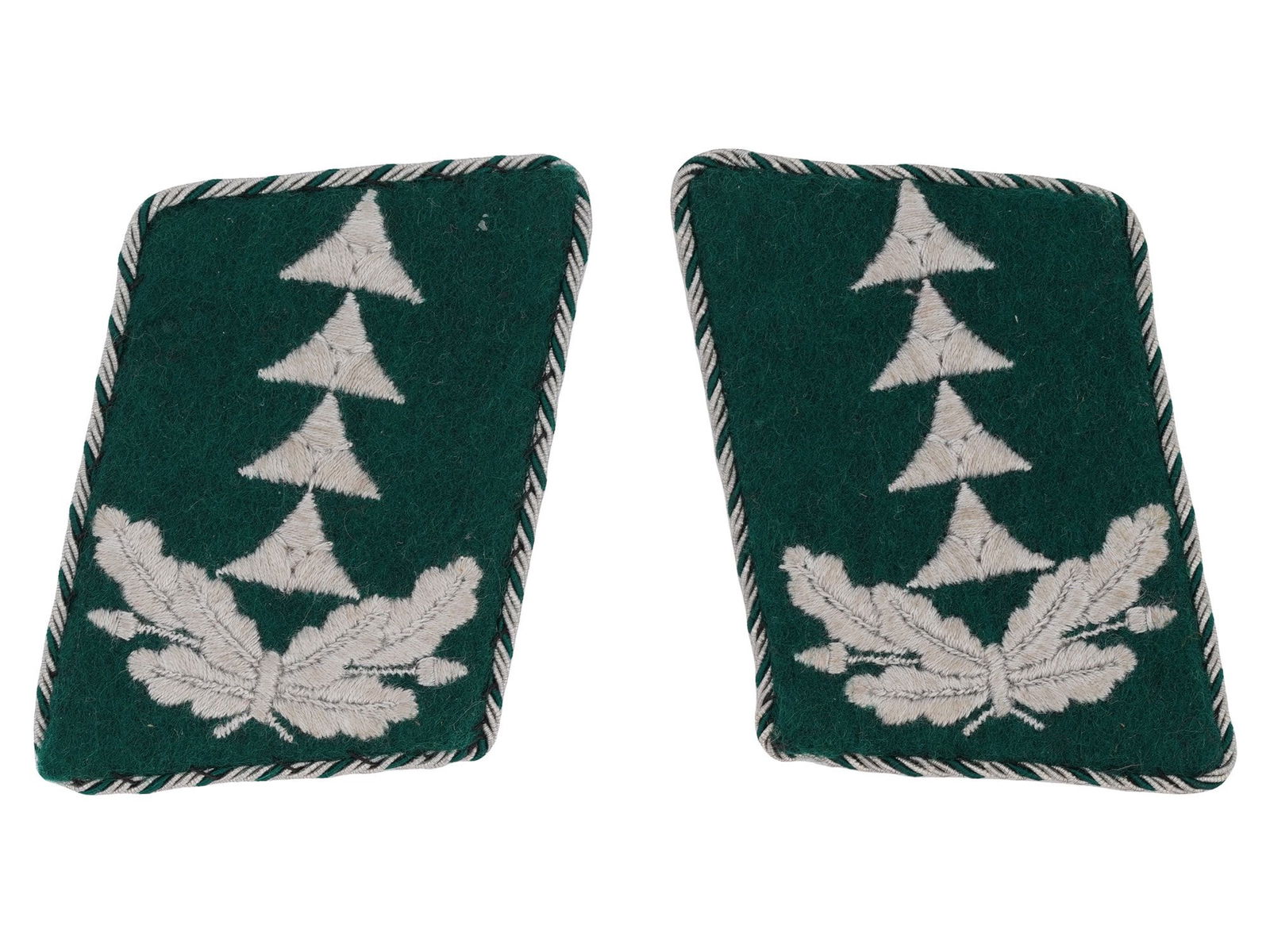 WWII GERMAN LUFTWAFFE OFFICIALS COLLAR TABS: A pair of WWII German Luftwaffe administrative officials collar tabs. The color tabs are made of green wool with white embroidered geometric patterns reminiscent of airplanes, as well as tied oak leav