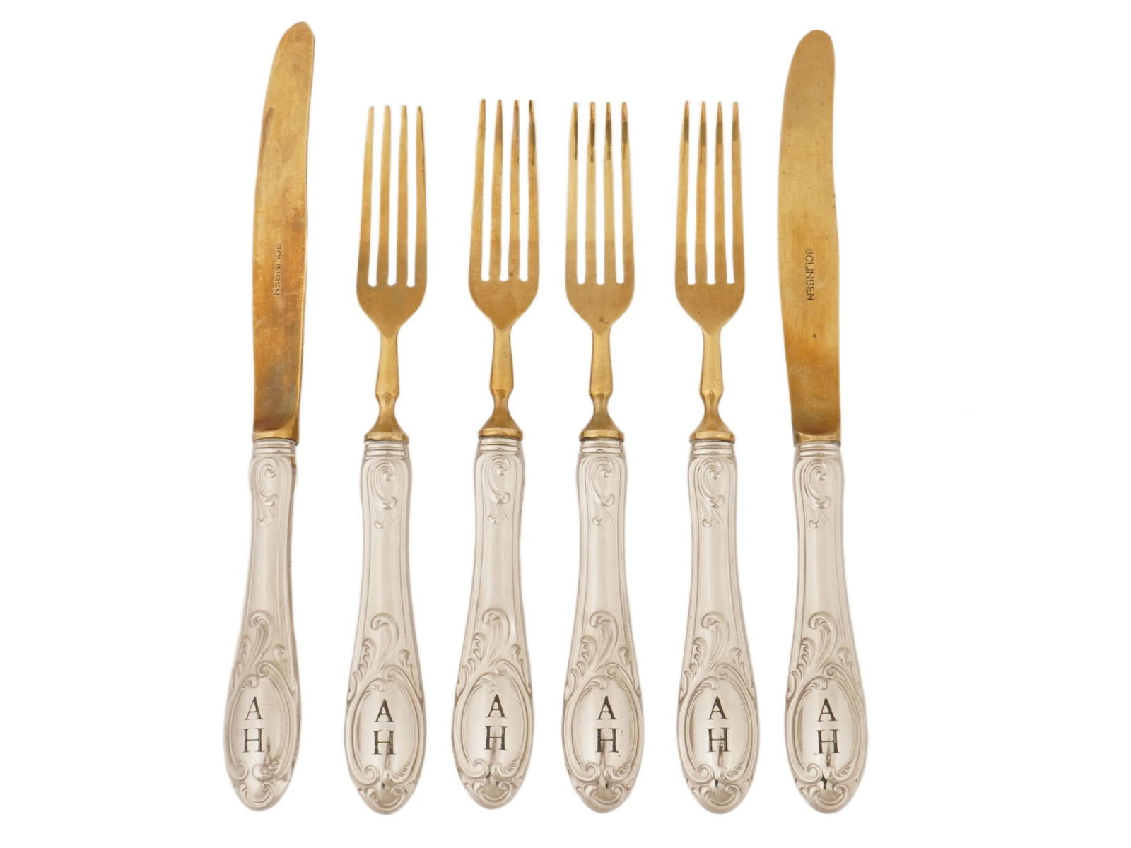 ADOLF HITLER MONOGRAMMED SOLINGEN CUTLERY SET: A set of vintage dinner cutlery, a total of 2 knives and 4 forks. Golden blades, the knives are marked Solingen. The handle tips are engraved with initials AH referring to Adolf Hitler. Second World W