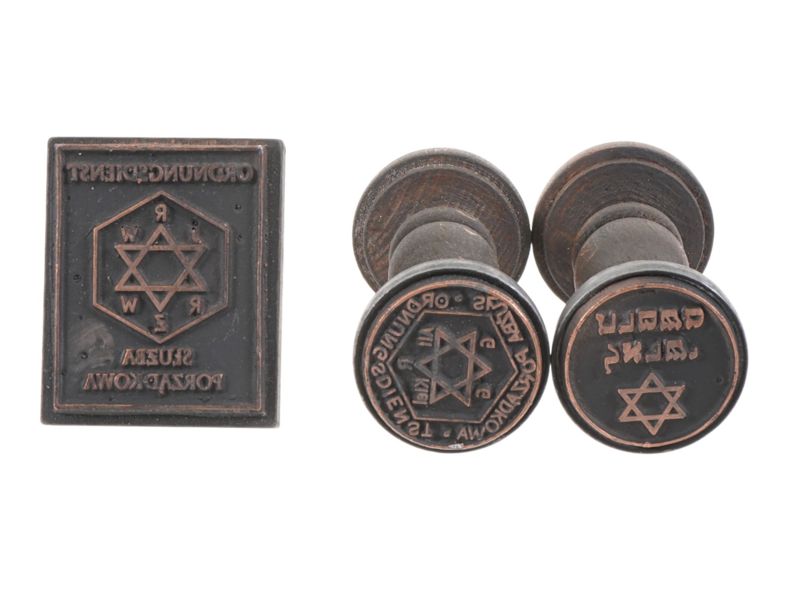 WWII NAZI WARSAW GHETTO HOLOCAUST HAND INK STAMPS: A group of three WWII Nazi German Holocaust hand ink stamps, associated with administrative and enforcement bodies operating within the Warsaw Ghetto during World War II. The group includes stamps att