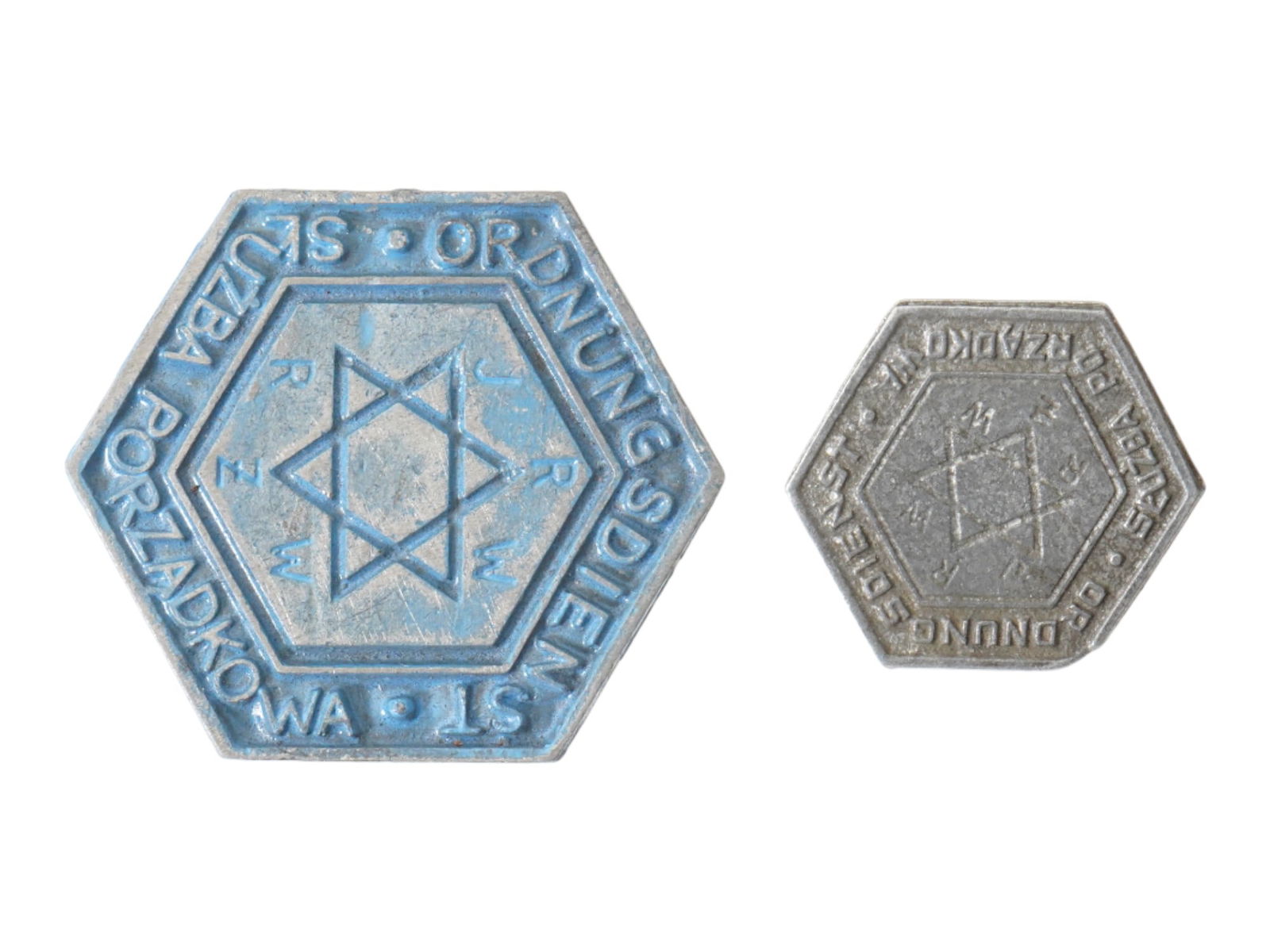 LOT WWII TYPE WARSAW GHETTO POLICE BREAST HAT BADGES: A lot of two WWII type Warsaw Jewish ghetto police Ordnungsdienst badges including a hat abdge and a breast badge. One badge is a brass hexagon decorated with blue enamel, comprises a Star of David to