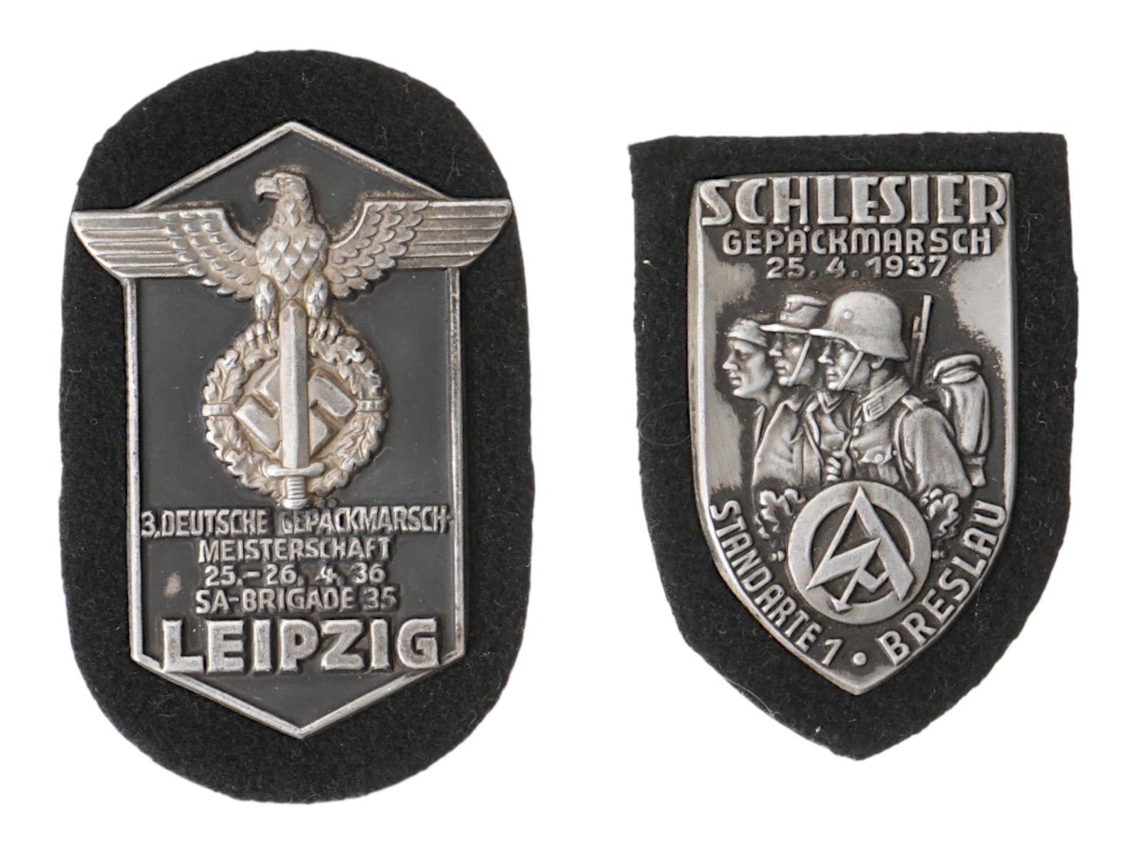 TWO WWII NAZI GERMAN SA COMMEMORATIVE SHIELDS: A group of two WWII Nazi German SA commemorative shields. The first commemorates the 1936 SA Brigade Leipzig, associated with Leipzig, and the second marks the 1937 SA Standarte 1 Breslau Backpack Tou