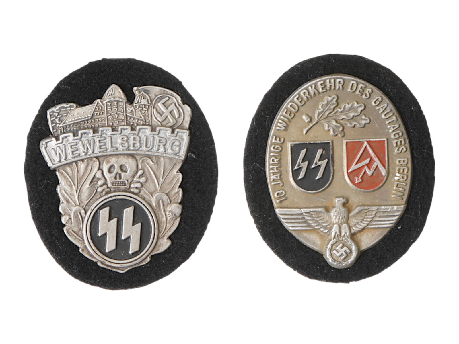TWO WWII NAZI GERMAN WAFFEN SS COMMEMORATIVE SHIELDS: A group of two WWII Nazi German Waffen SS commemorative shields. The first relates to the SS Academy at Wewelsburg Castle, a site used by the Schutzstaffel for ideological training, while the second c