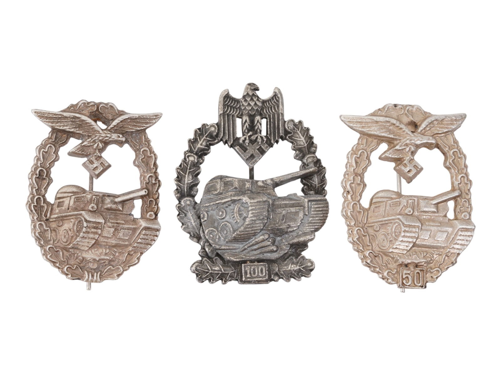 LOT OF WWII MODEL GERMAN LUFTWAFFE TANK BATTLE BADGES: A collection of three WWII model Nazi German Luftwaffe tank battle badges. The lot includes 3 Actions, 50 Actions, 100 Actions. Each badge is adorned with a relief design representing a tank, a Nazi e