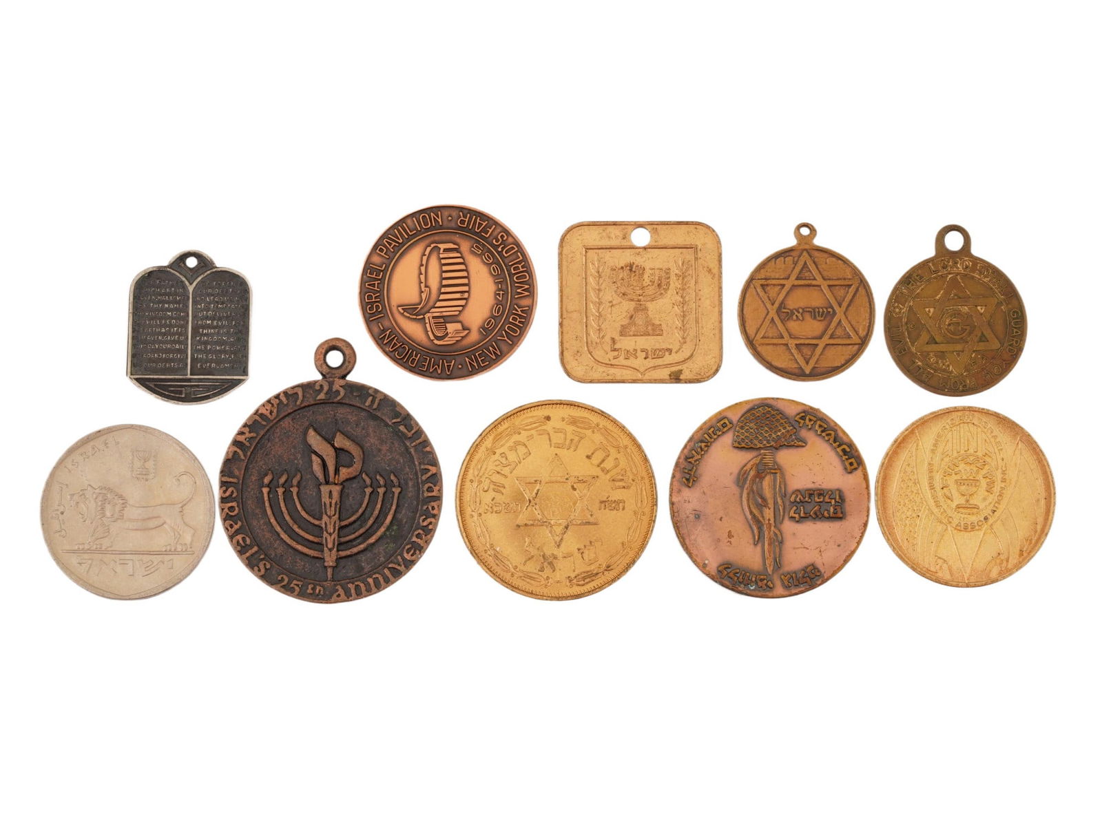 VINTAGE ISRAELI COMMEMORATIVE MEDALS AND TOKENS: A varied group of Israeli commemorative medals and tokens, spanning key national and cultural milestones, including several issues marking the 25th anniversary of the State of Israel in 1973. Also