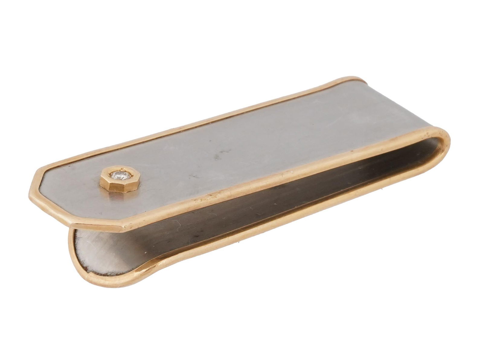 ANTIQUE 14K GOLD SILVER AND DIAMOND MONEY CLIP: An early 20th-century American money clip. Sterling silver piece with 14K yellow gold rims, embellished with a diamond on the obverse. Marked 14K, SS on the inner rim. Total Weight: 12 grams. Elegant