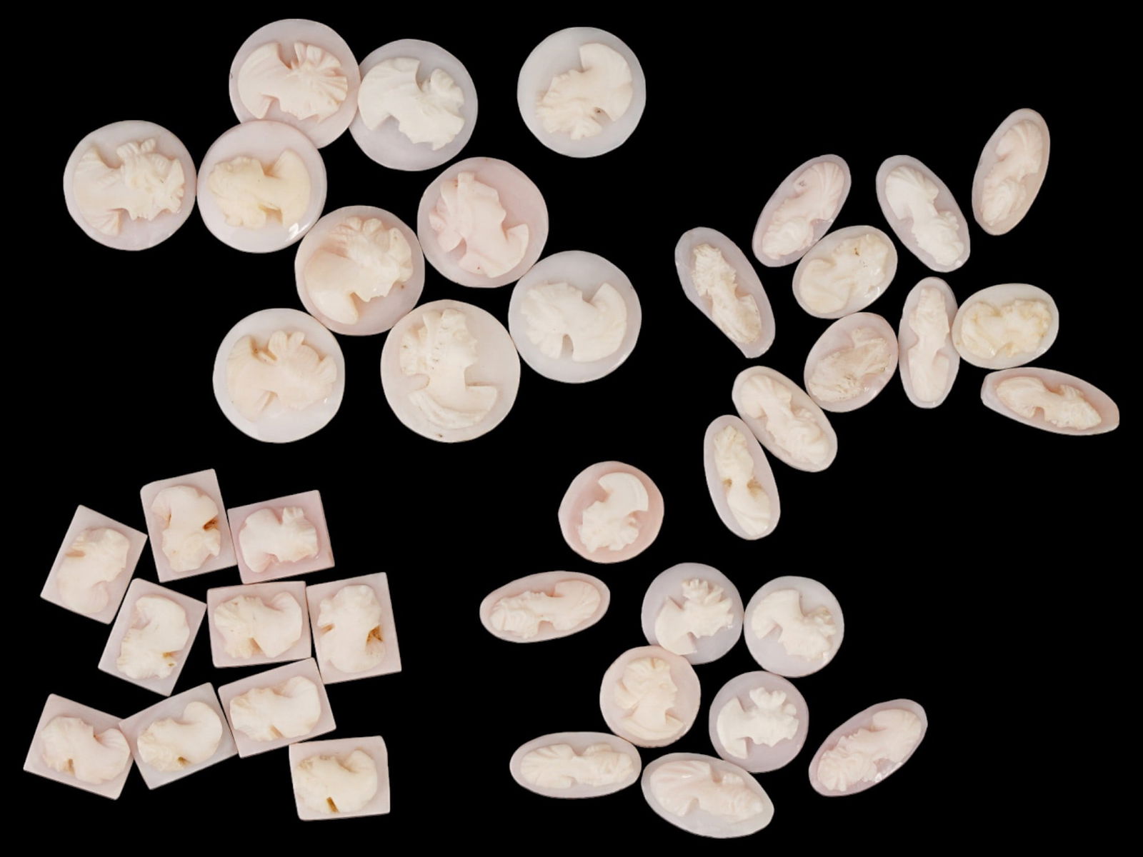 COLLECTION OF ANTIQUE HAND CARVED SHELL CAMEOS: A collection of antique hand carved cameos, dating back to the early 20th century. A total of 40 items. Each piece is crafted from conch shell, featuring female profile portraits rendered in high reli