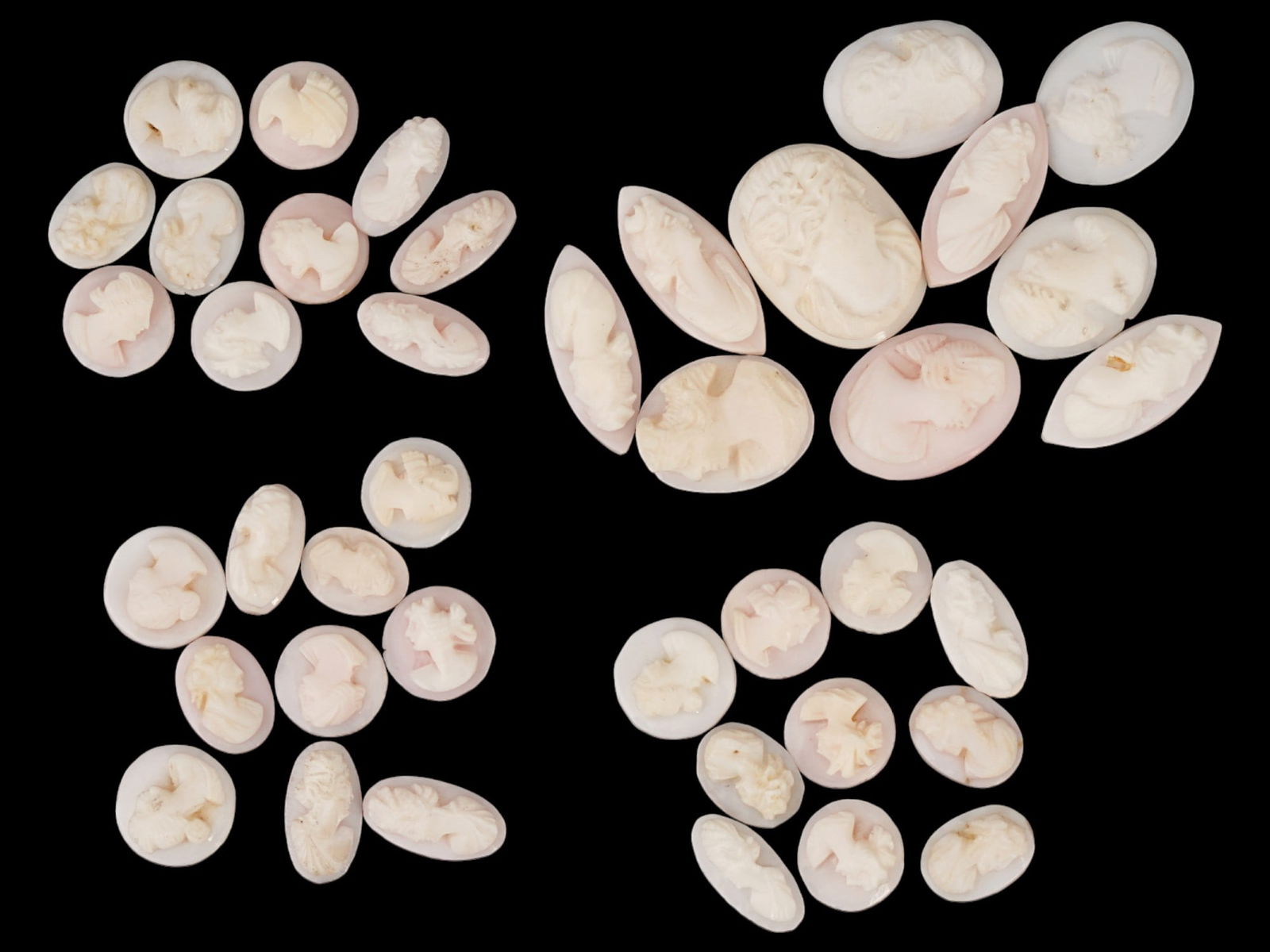 COLLECTION OF ANTIQUE PORTRAIT CARVED SHELL CAMEOS: A collection of forty antique hand carved cameos, dating back to the early 20th century. Each piece is crafted from conch shell, featuring female profile portraits rendered in high relief. Oval, drop