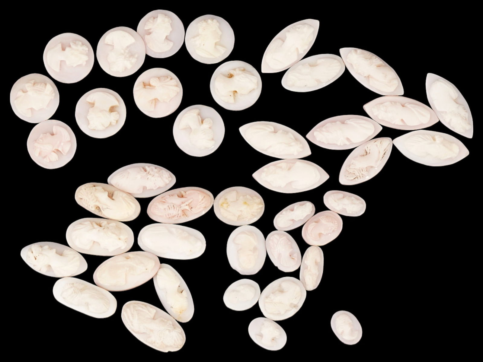 COLLECTION OF ANTIQUE PORTRAIT CARVED SHELL CAMEOS: A collection of forty one antique hand carved cameos, dating back to the early 20th century. Each piece is crafted from conch shell, featuring female profile portraits rendered in high relief. Oval, d
