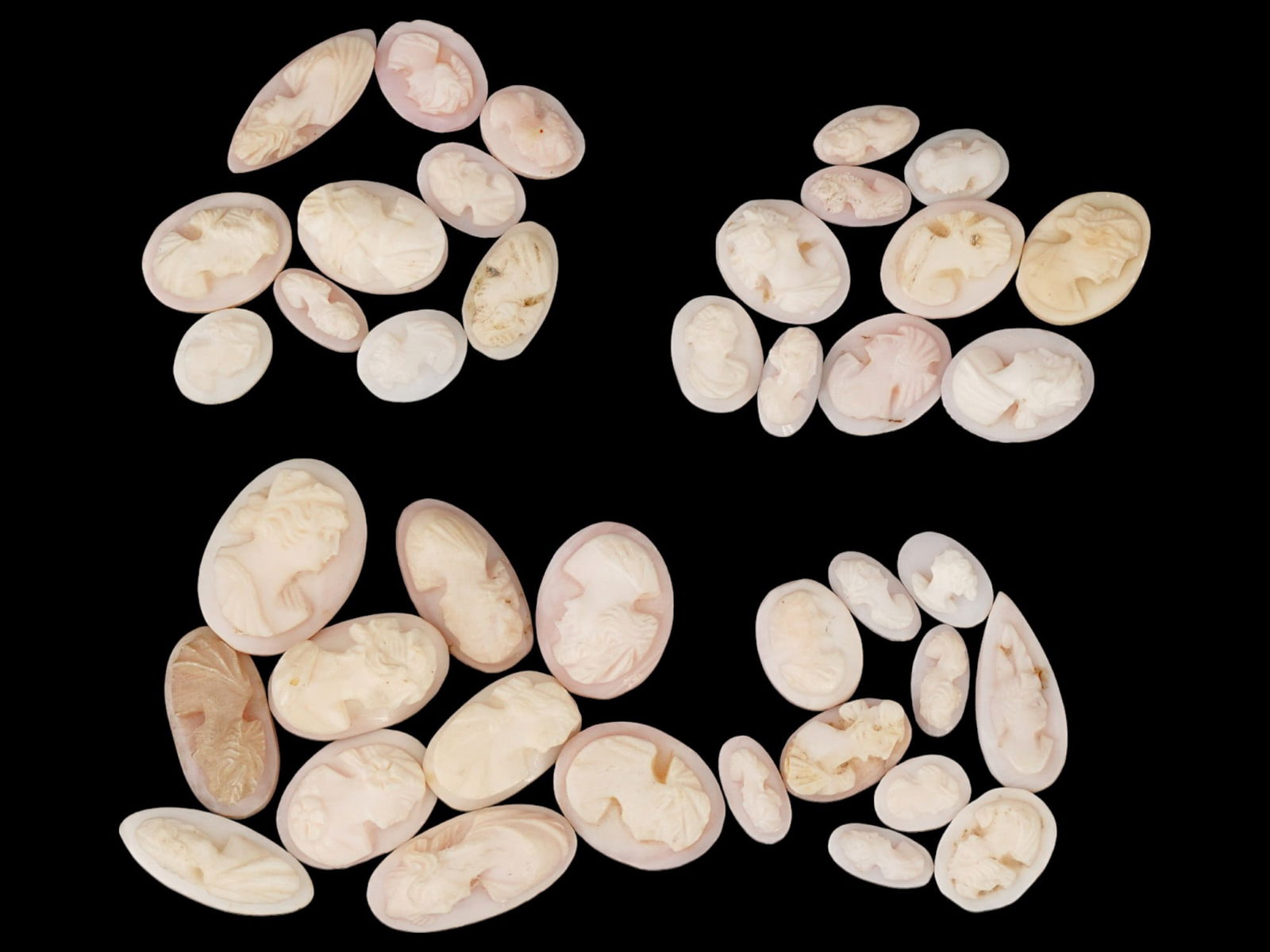 COLLECTION OF ANTIQUE PORTRAIT CARVED SHELL CAMEOS: A collection of forty antique hand carved cameos, dating back to the early 20th century. Each piece is crafted from conch shell, featuring female profile portraits rendered in high relief. Oval and dr
