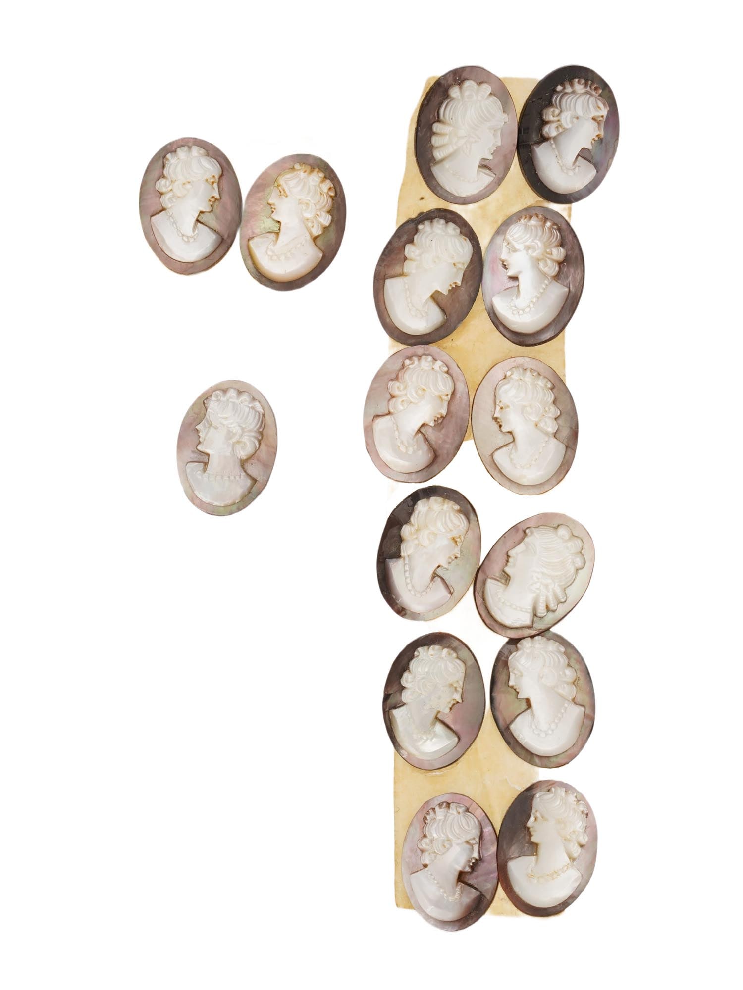 COLLECTION OF ANTIQUE PORTRAIT CARVED SHELL CAMEOS: A collection of fifteen antique hand carved cameos intaglios, dating back to the early 20th century. Each piece is crafted from conch shell, featuring female profile portraits rendered in high relief.