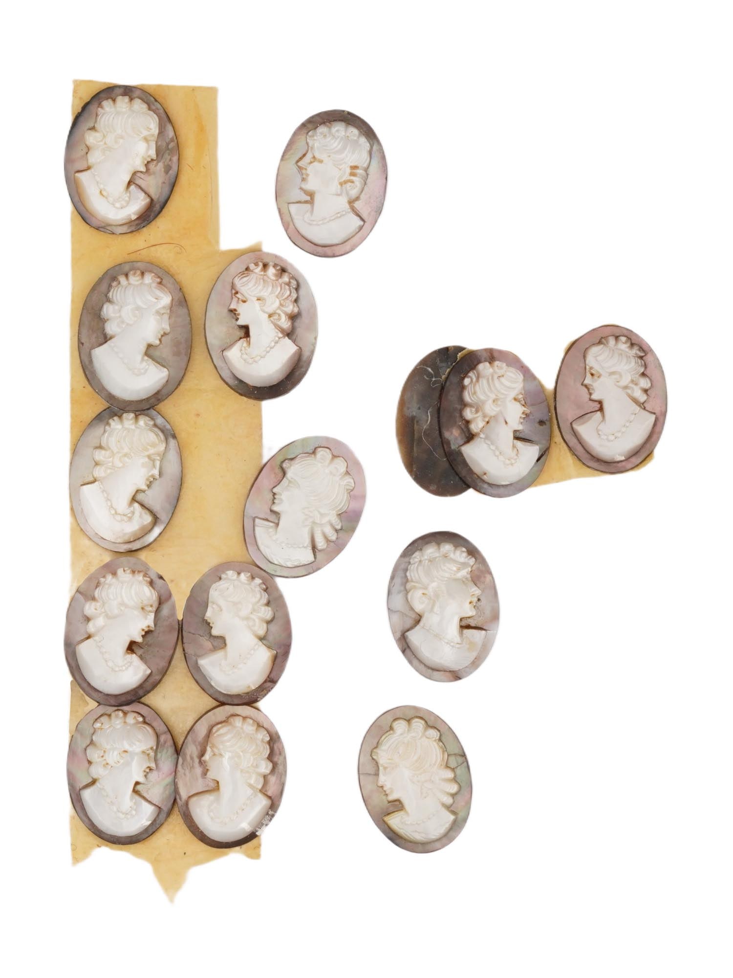 COLLECTION OF ANTIQUE HAND CARVED CAMEOS: A collection of 15 antique hand-carved cameos, dating to the early 20th century, each crafted from conch shell in the traditional oval form. The cameos depict female profile portraits in high relief,