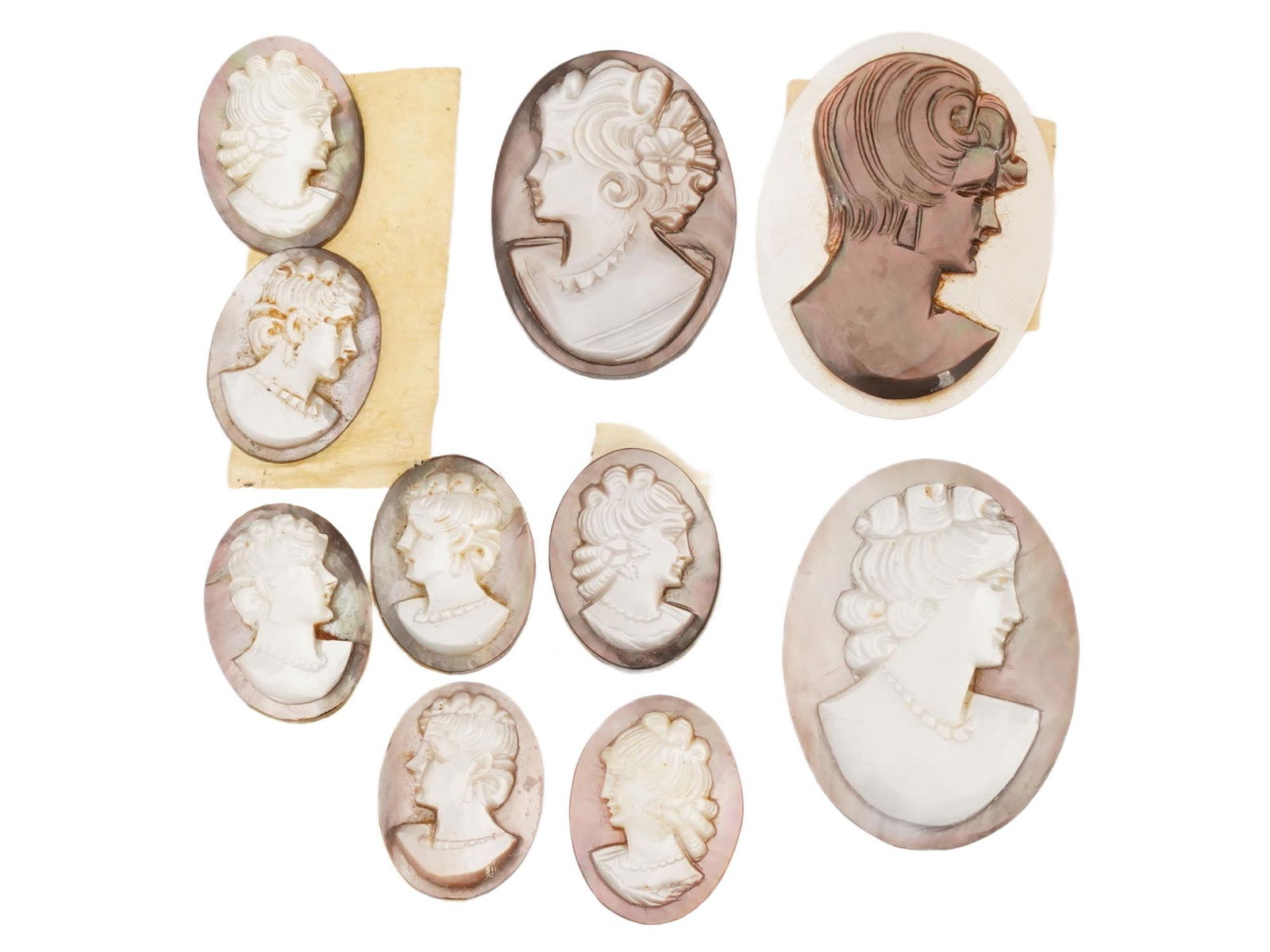 COLLECTION OF ANTIQUE HAND CARVED SHELL CAMEOS: A collection of 10 antique hand-carved cameos, dating to the early 20th century, each crafted from conch shell in the traditional oval form. The cameos depict female profile portraits in high relief,