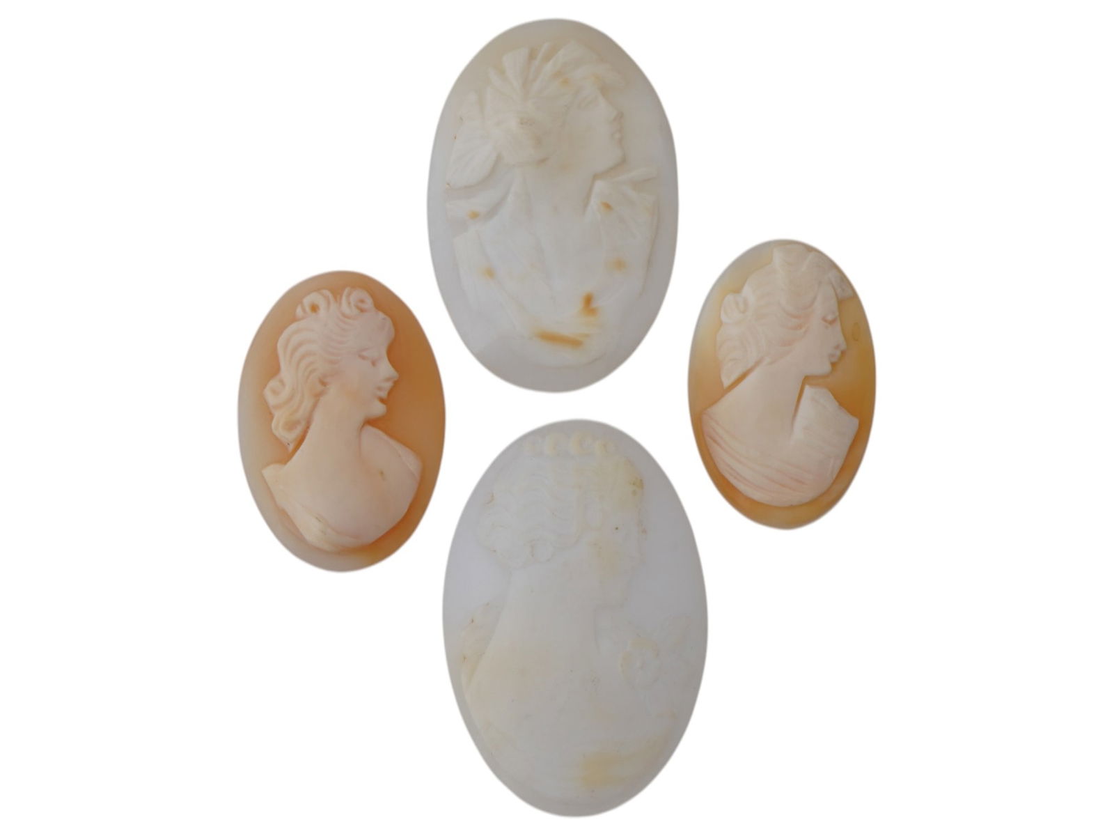 COLLECTION OF PORTRAIT CARVED SHELL CAMEO MEDALLIONS: A collection of four vintage cameo medallions in various sizes. Each oval cut shell cameo depicts a relief female portrait in profile in the Victorian or Roman manners. Vintage Jewelry And Accessories