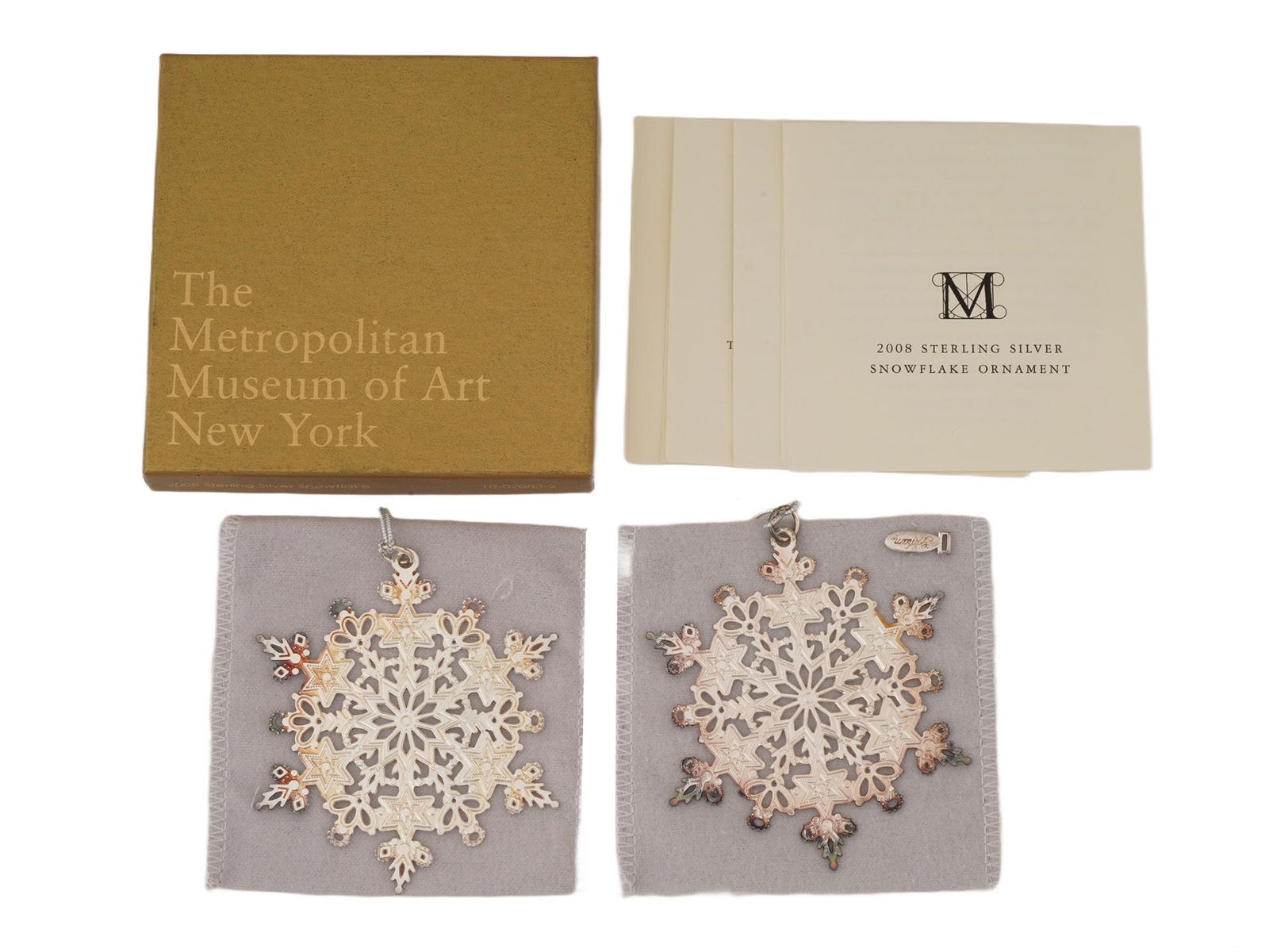 2008 SILVER SNOWFLAKE ORNAMENTS METROPOLITAN MUSEUM: A 2008 annual sterling silver snowflake ornament issued by the Metropolitan Museum of Art, part of the museums long-running holiday ornament series introduced in the 1970s. Manufactured by Gorham.