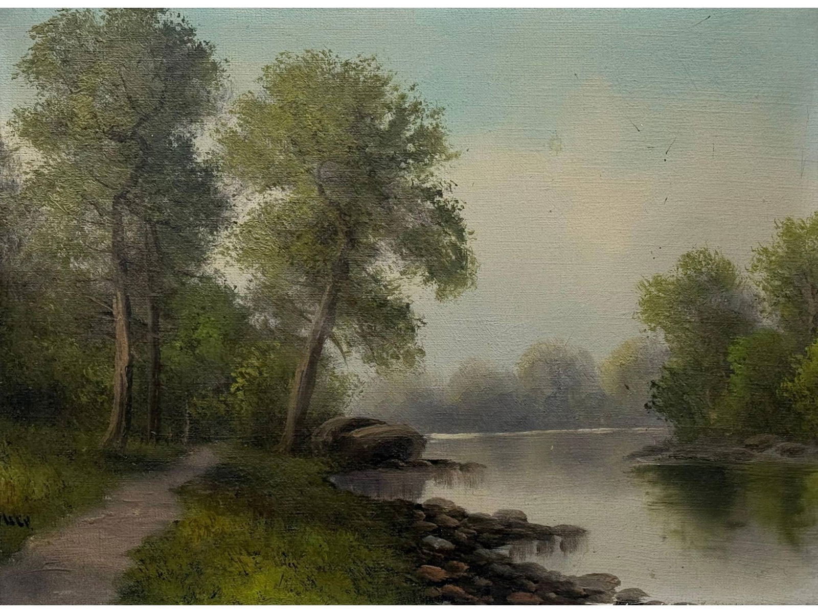 EARLY 20TH C AMERICAN SCHOOL OIL LANDSCAPE PAINTING: An American School coastal landscape oil on canvas painting featuring a winding river, lush trees, and a hazy, atmospheric sky. Circa early 20th-century. Antique And Vintage American Paintings And Art