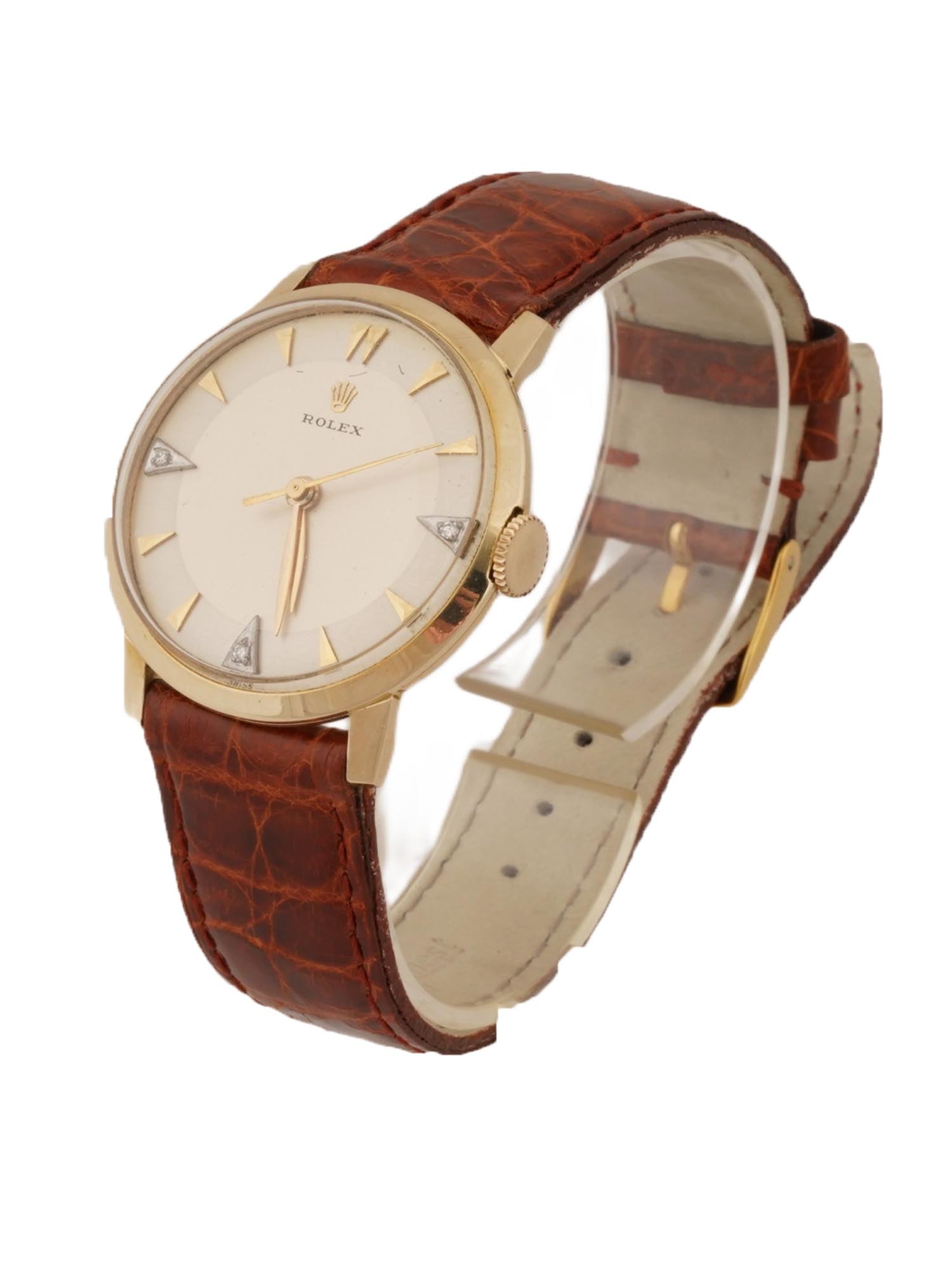 ROLEX 14K GOLD WRISTWATCH W DIAMONDS AND LEATHER STRAP: A Rolex 14k gold wristwatch featuring a classic dial with signature triangular diamond markers at the 3, 6, and 9-hour positions. It has a leather brown strap, marked Made in Italy, genuine crocodile.