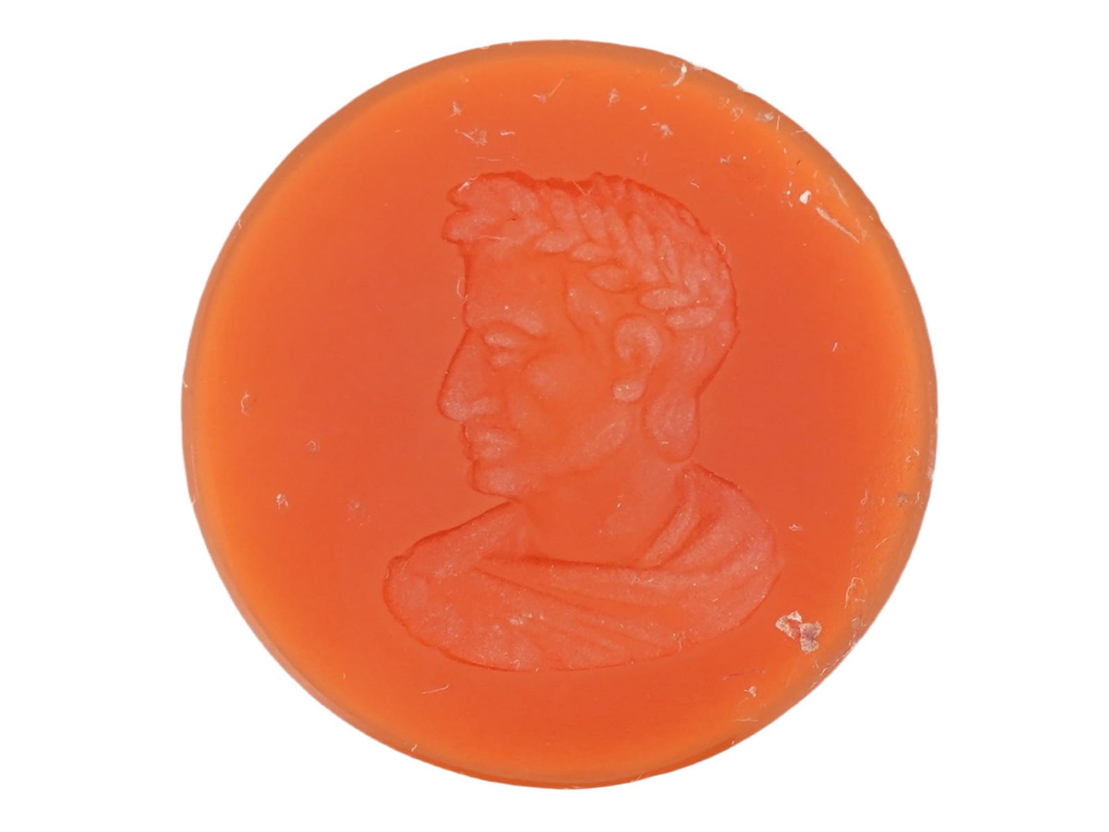 ROMAN MANNER HAND CARVED CAESAR CARNELIAN INTAGLIO SEAL: A Roman manner hand carved carnelian stone intaglio seal. The intaglio is adorned with an incised design representing a male profile of a Caesar. Round in shape. The reverse side is flat. Ancient Roma