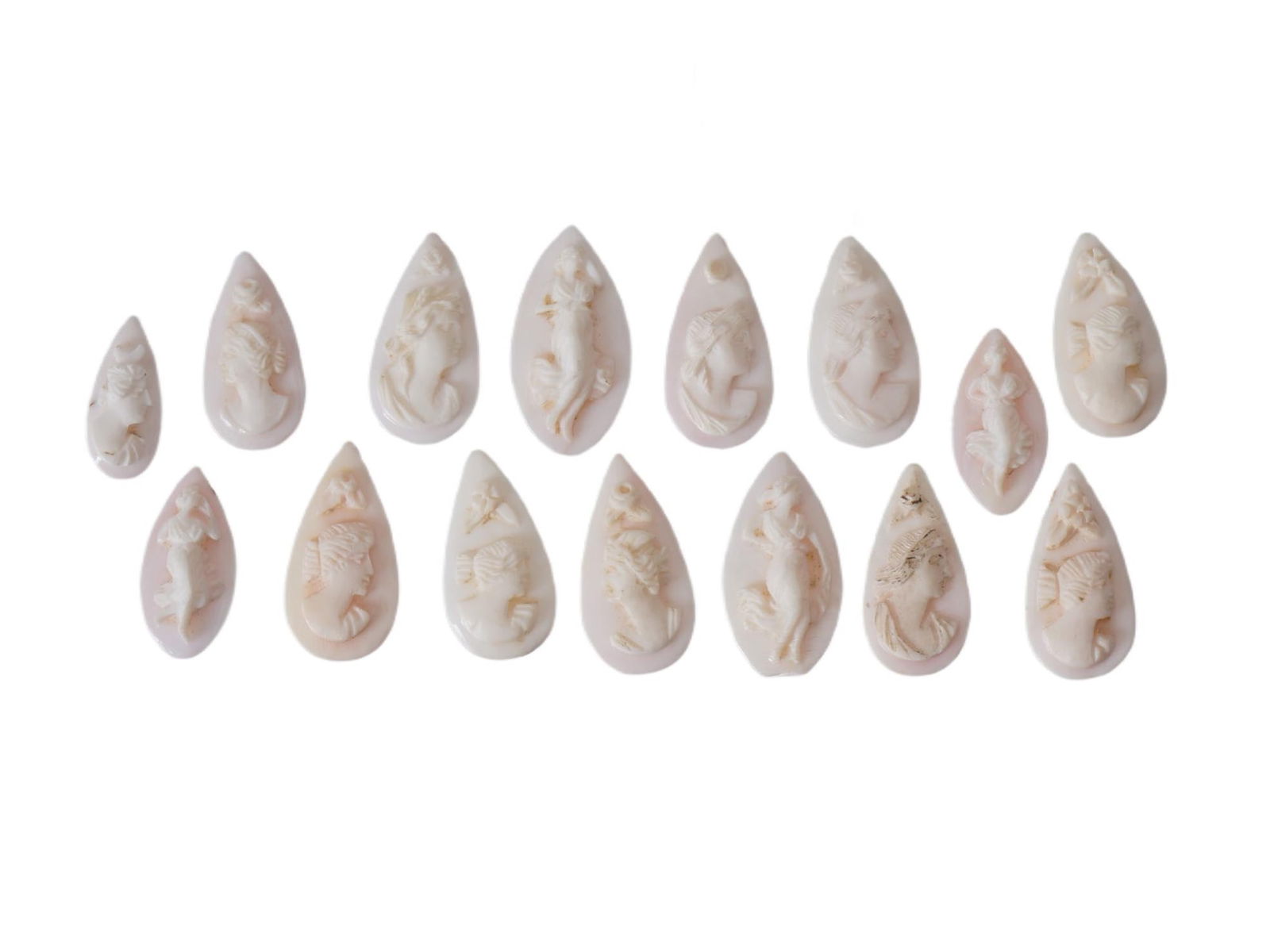 COLLECTION OF FEMALE PORTRAIT CARVED CORAL CAMEOS: A collection of hand carved pink coral cameos. A total of 15 items. Each piece depicts a female profile portrait rendered in high relief. Oval shape. Collectible Jewelry And Glyptic Art, Sculpture.